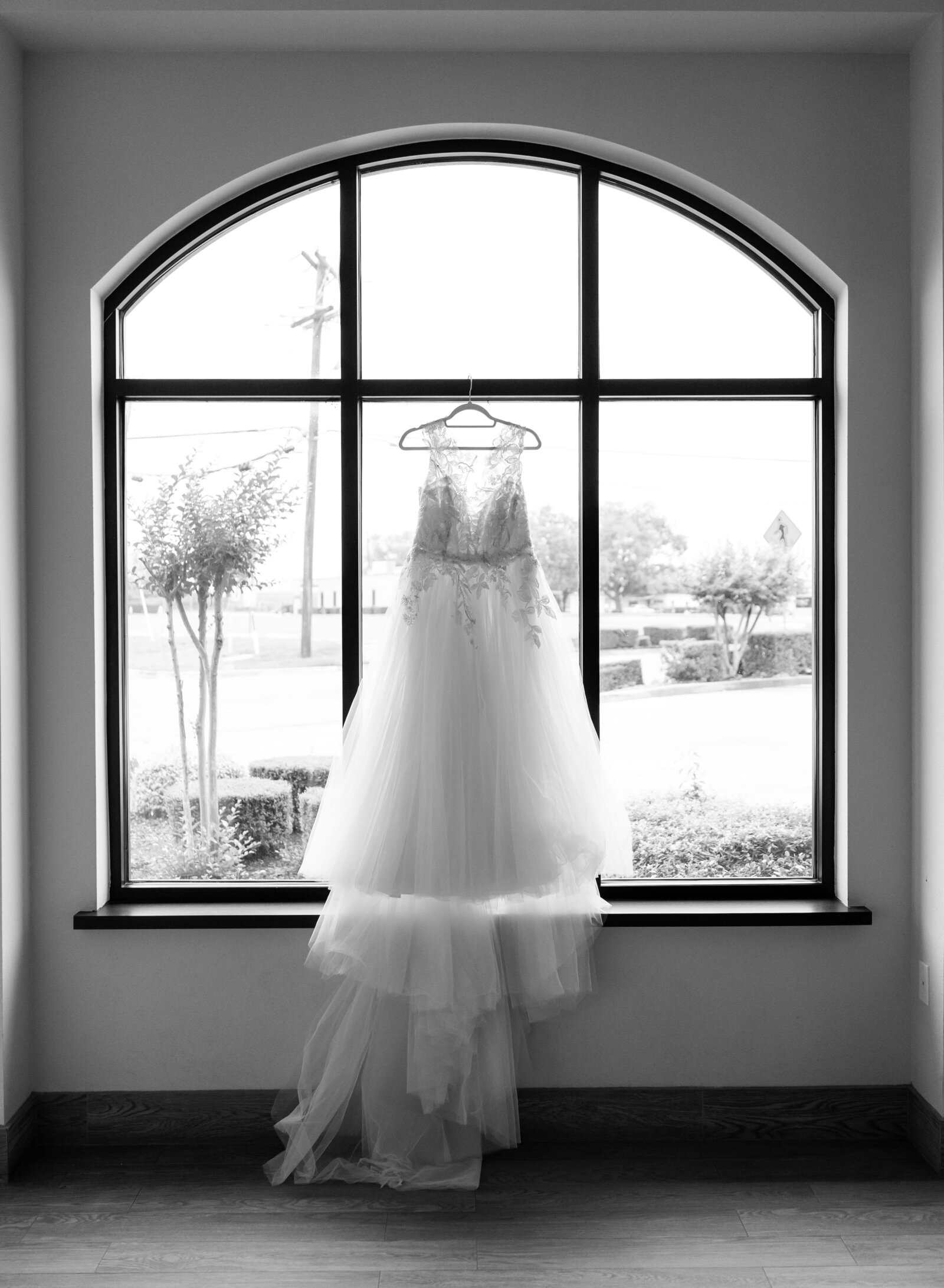 wedding dress hanging in window