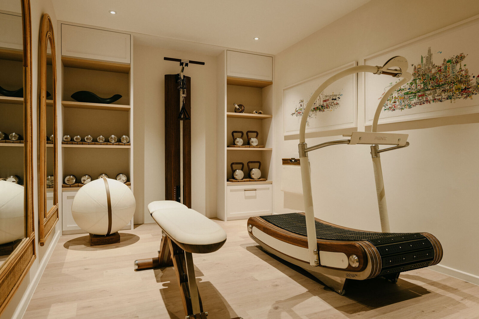 Private home gym with bespoke wood-accented treadmill, leather bench, and curated fitness equipment in a minimalist setting