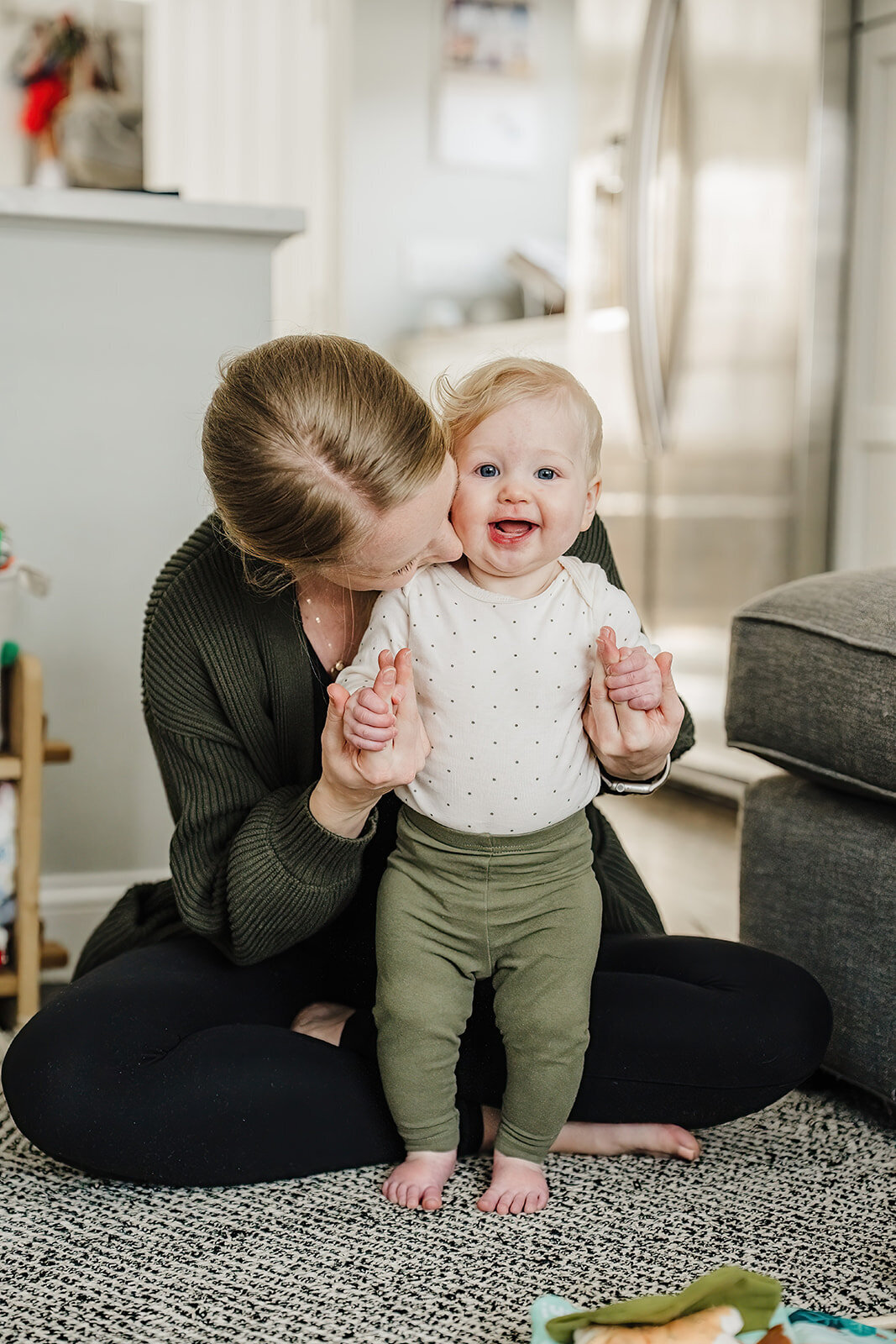 six month old baby smiles at camera during in home sitter session