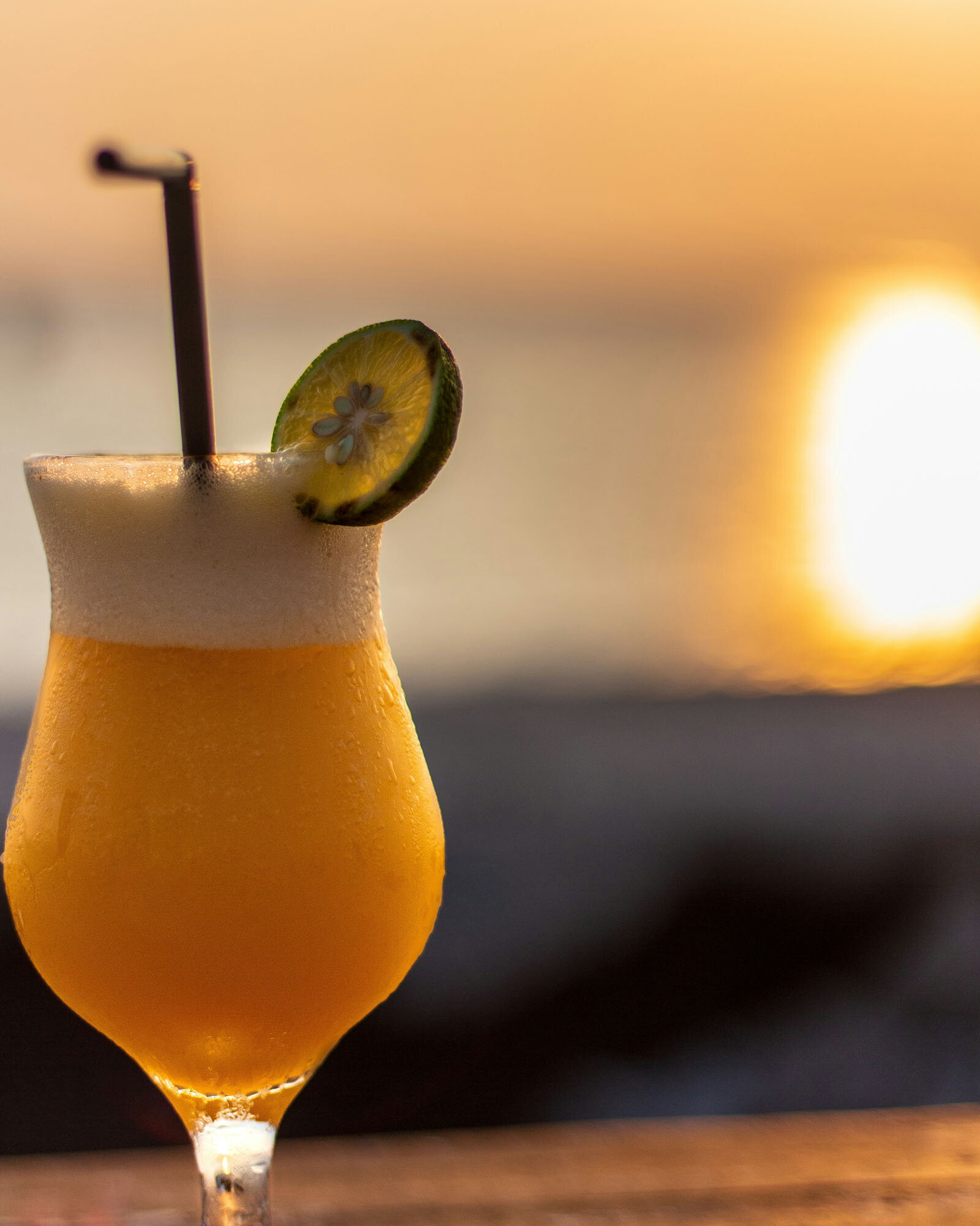 Yellow drink with a straw and a slice of lemon