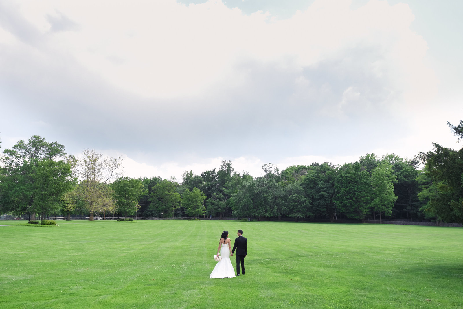 Bride and groom walking at the grounds of Glen Cove Mansion