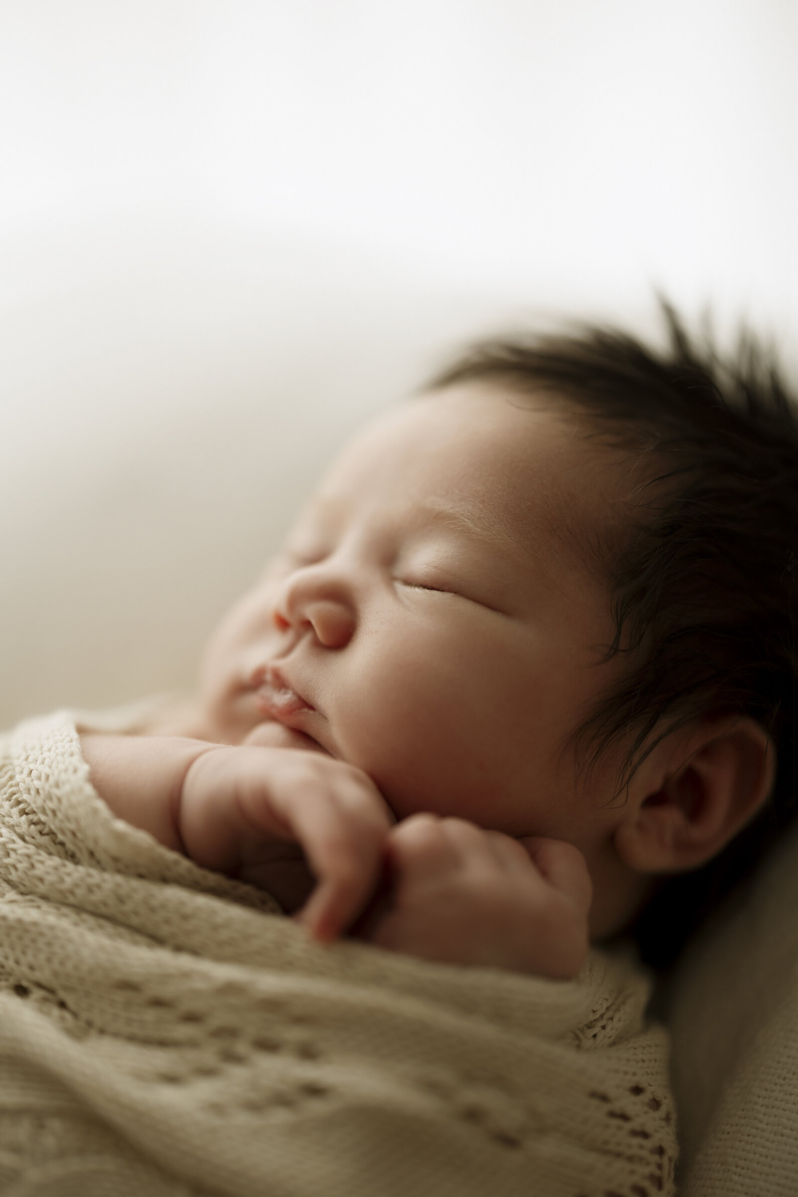 Newborn and parents studio photoshoot in Perth, featuring a timeless and loving embrace of a family with their newborn.