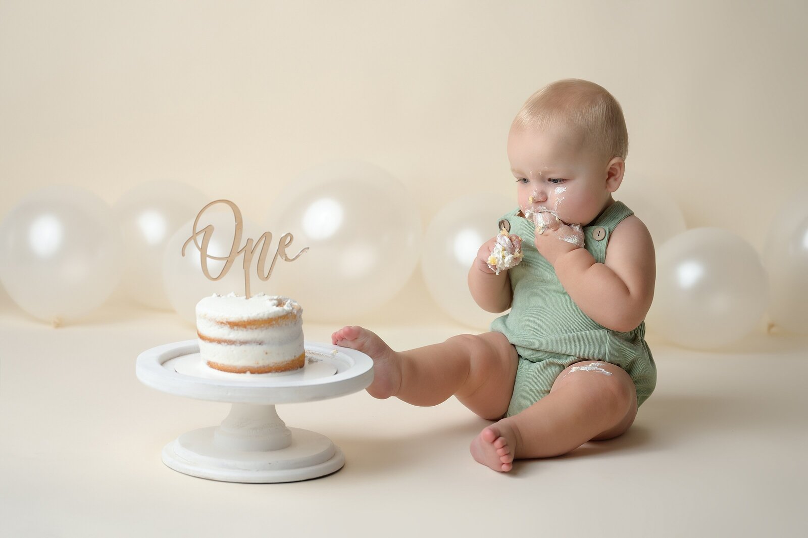 one year old eating cake for first birthday in Wellington