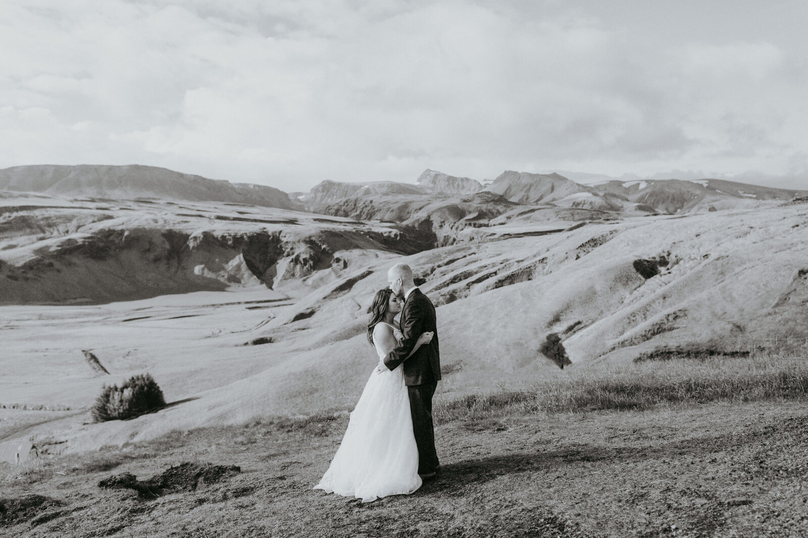 bride and groom kissing on mountain top in iceland highland wedding.
