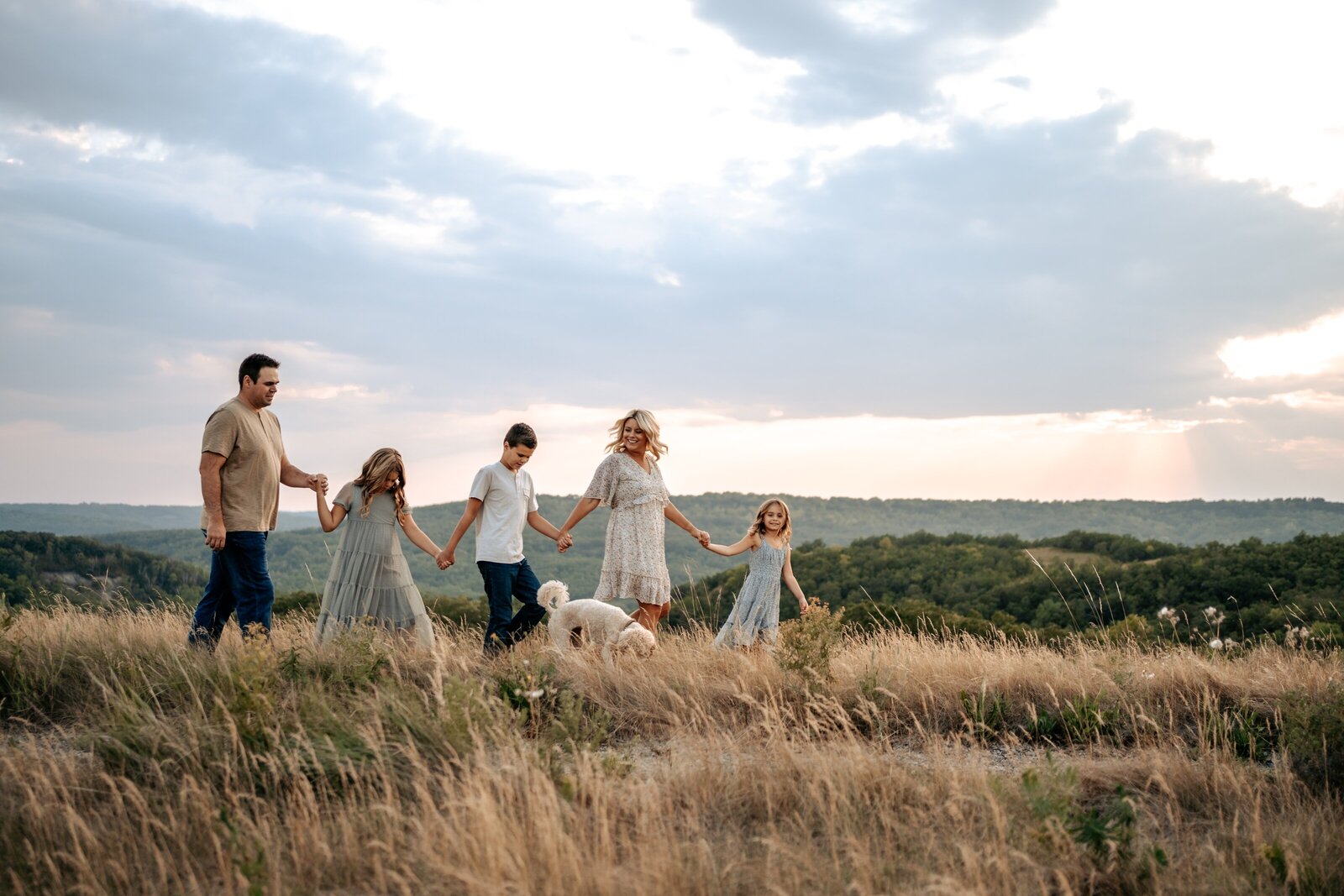 Family holding hands and walking across grassland