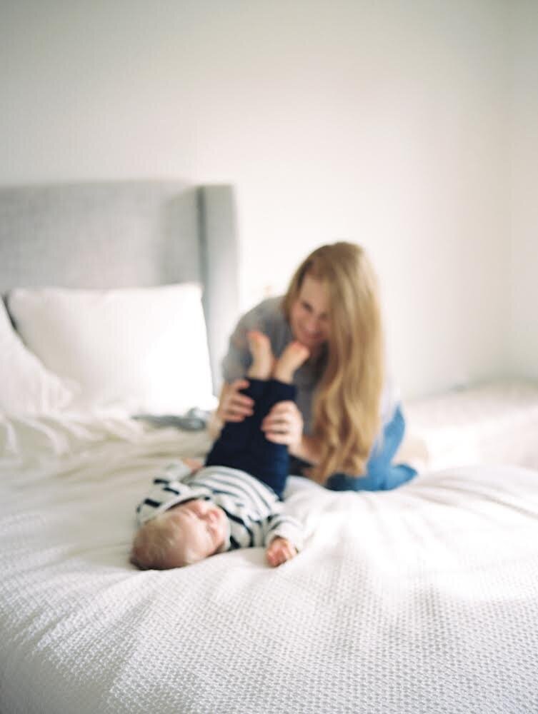 mother and son playing on the bed