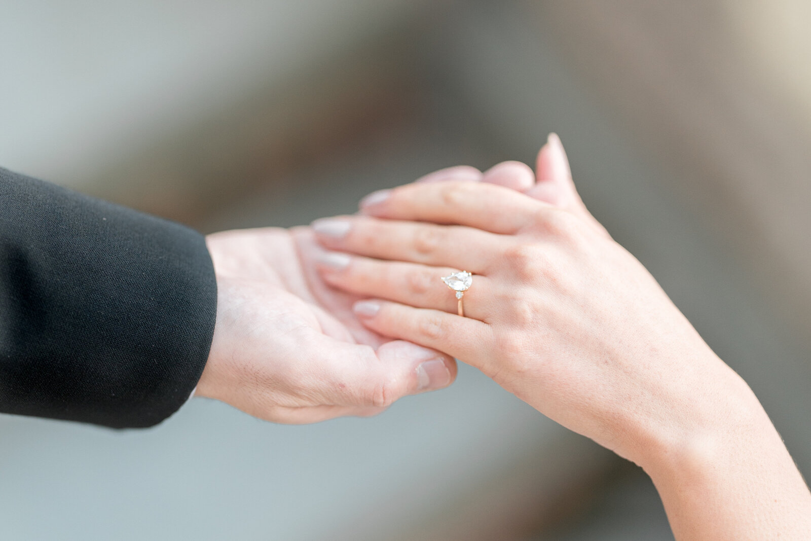 A close up a couple holding hands and featuring a diamond ring from Baxter's Fine Jewelery