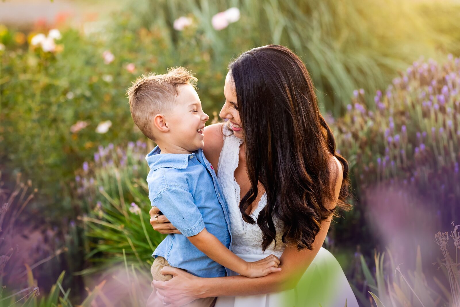 Mother and son smiling at each other in a flower field