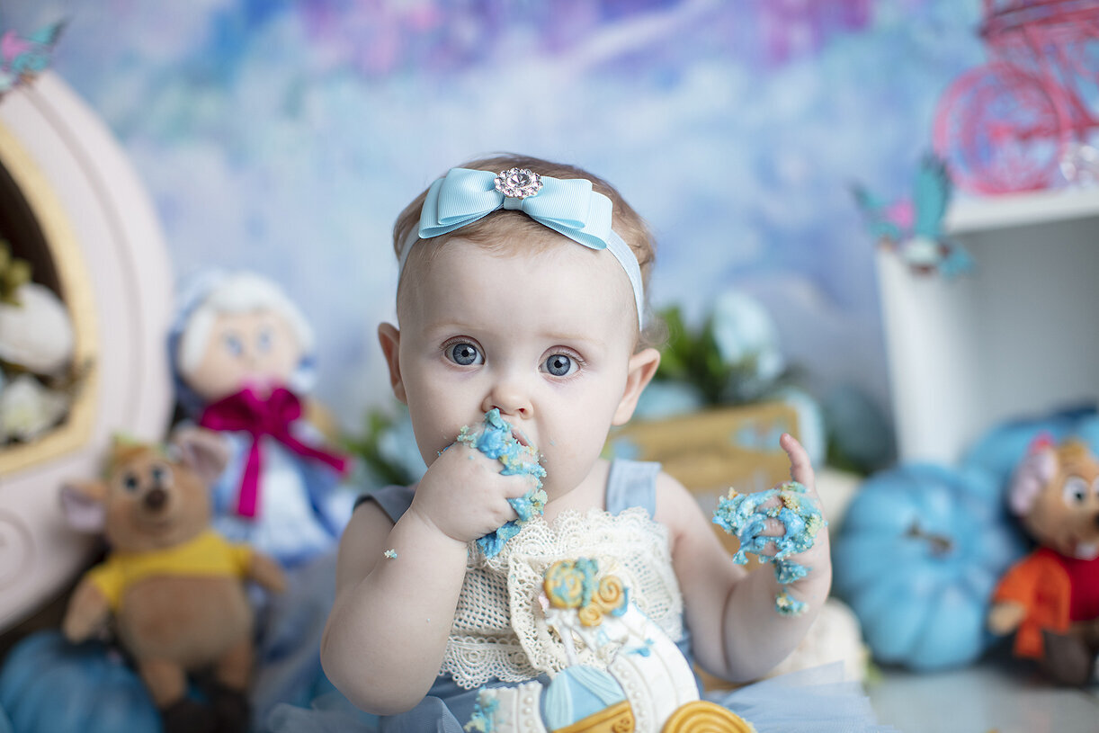 Baby girl eating cake, a Dallas cake smash photographer.