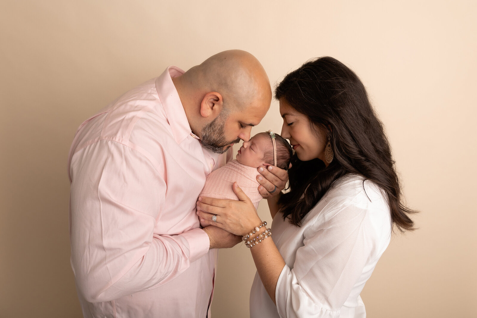 parents kissing new baby