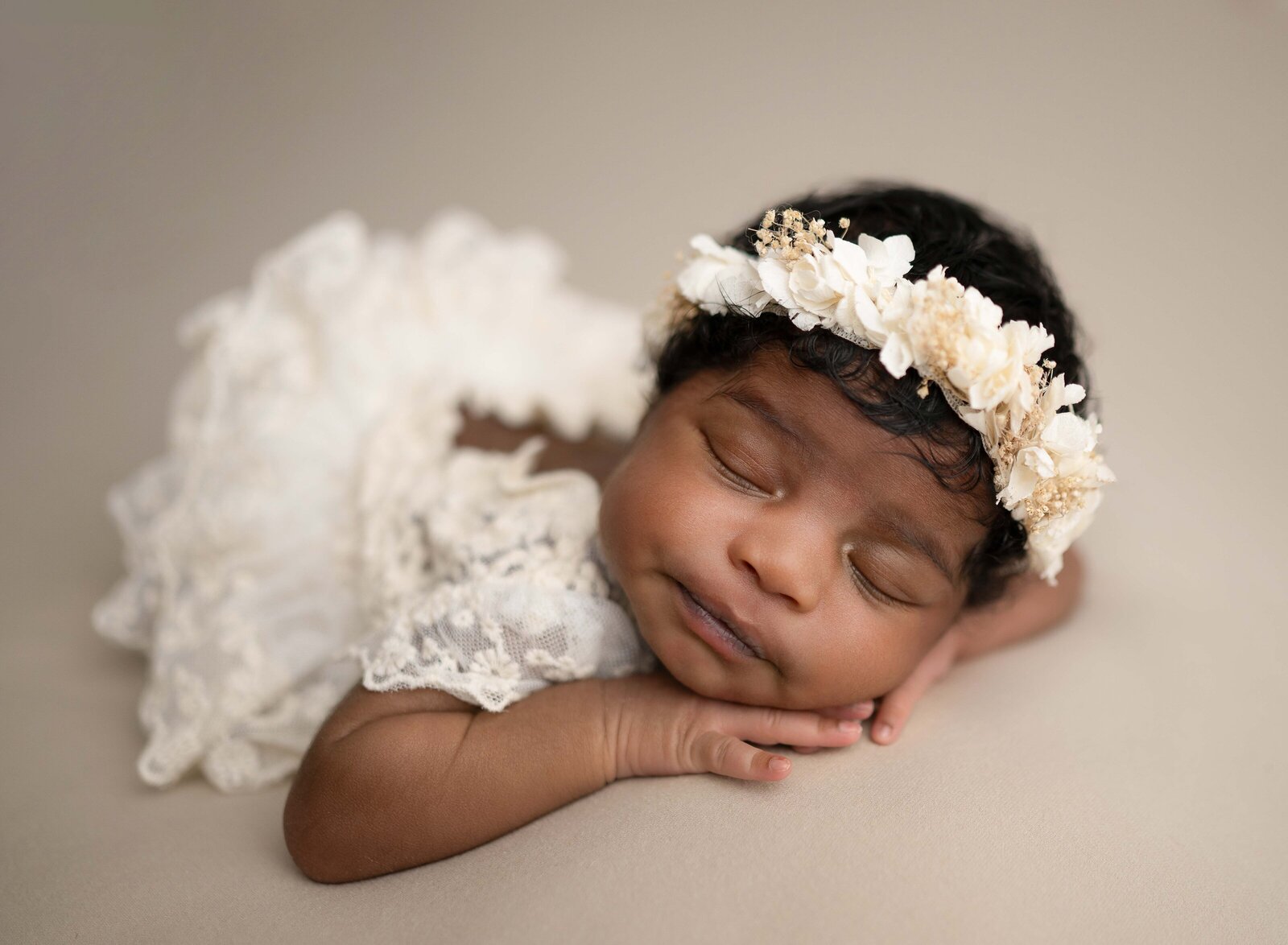 Baby girl in cream lace outfit and sleeping on her hands. Photographed by Jenni Nikki Photography at Marietta Newborn Photo Studio.
