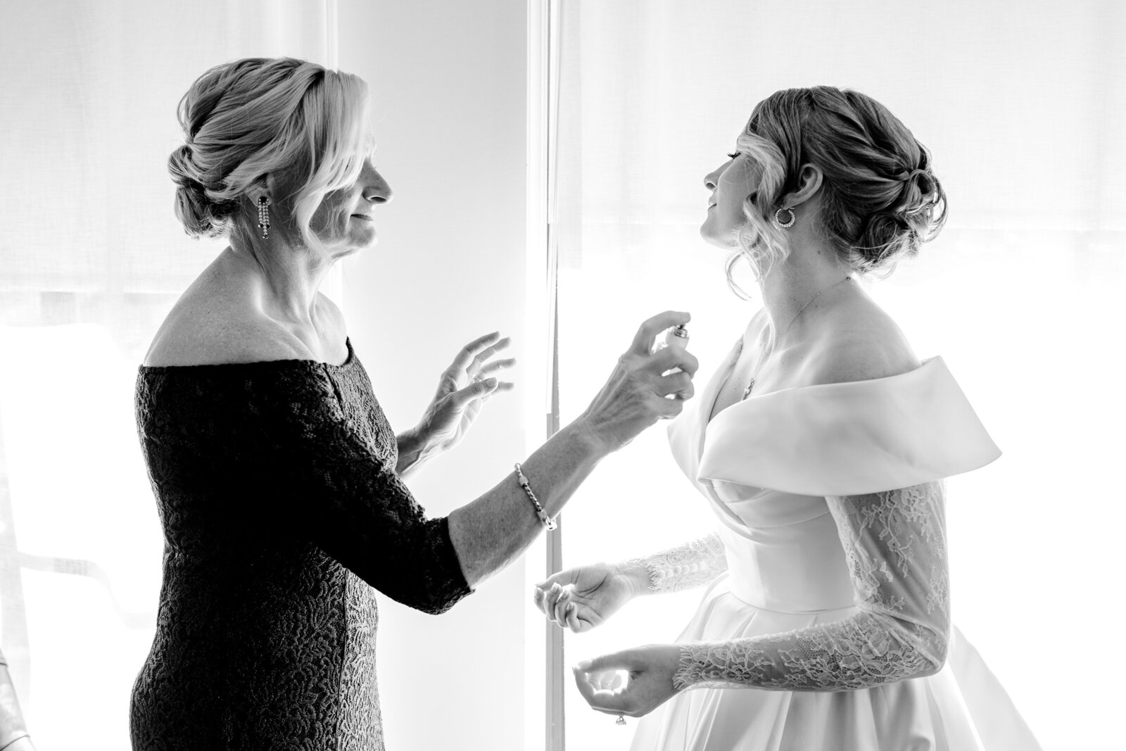 A bride's mother spraying perfume on the bride before her Catholic wedding in Washington DC