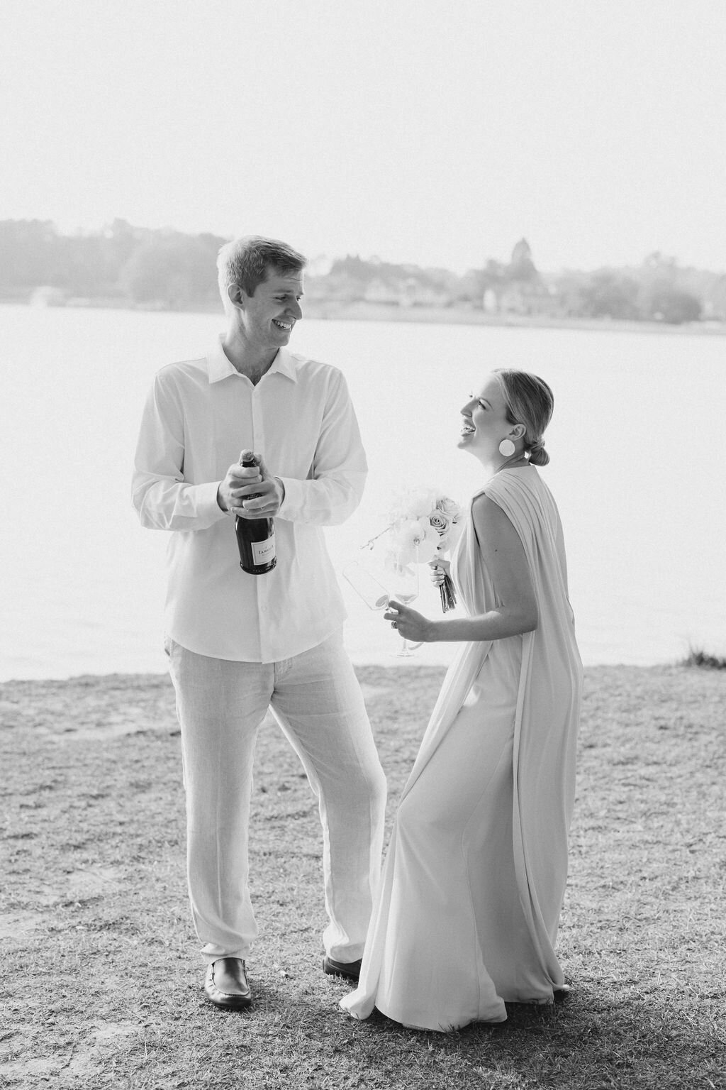 Couple dances together with champagne on shores of lake lanier