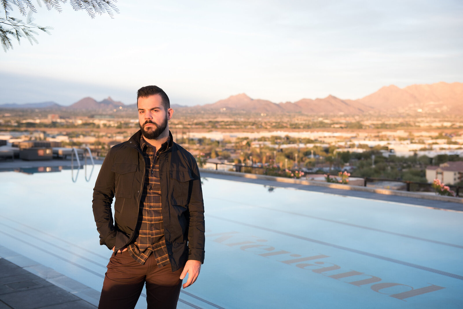 Brand image of Man standing  at  roof top pool