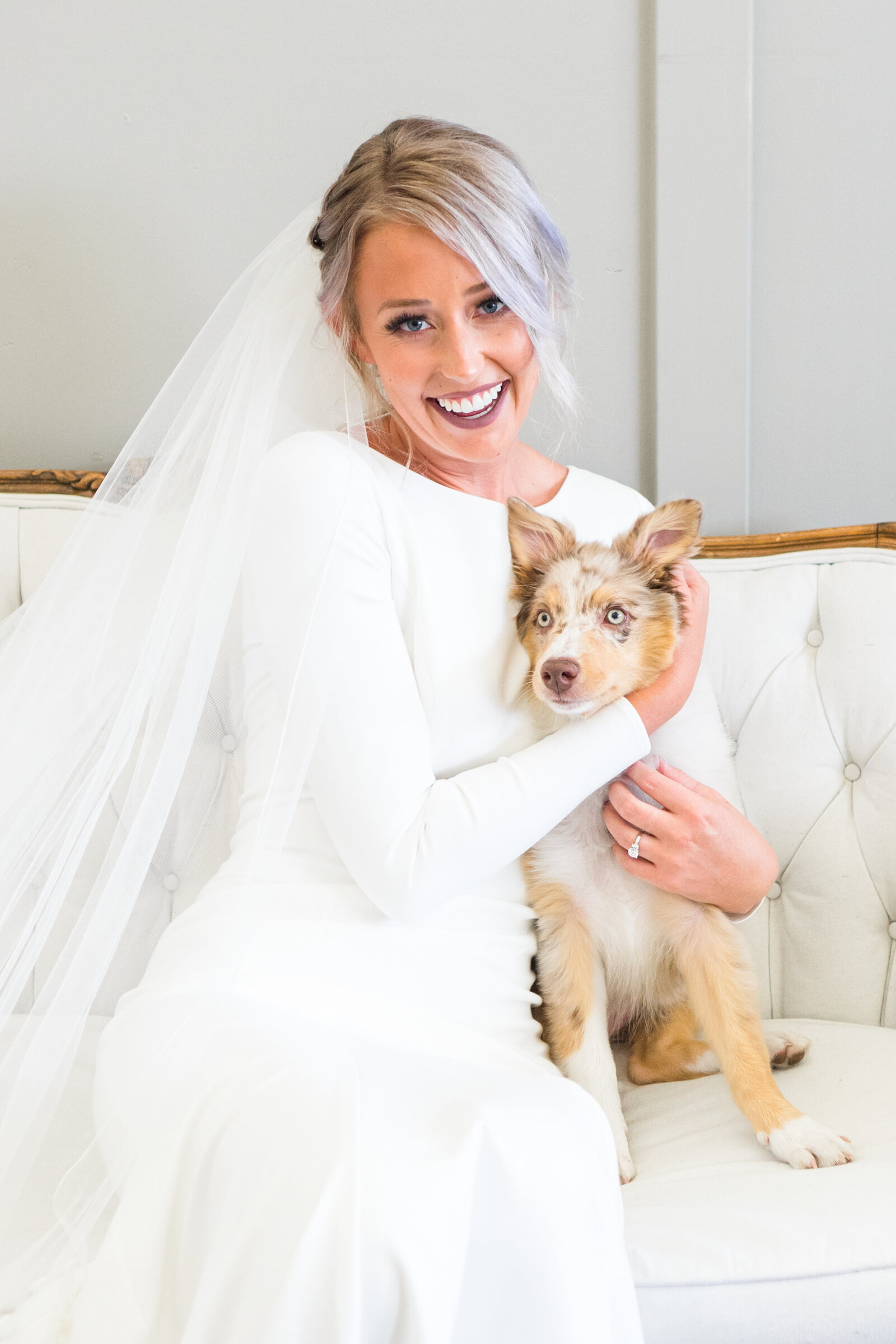Bride sitting on couch with puppy