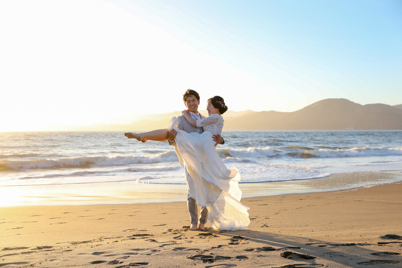 Couple lovingly poses in front of gorgeous sunset on the beaches of San Francisco