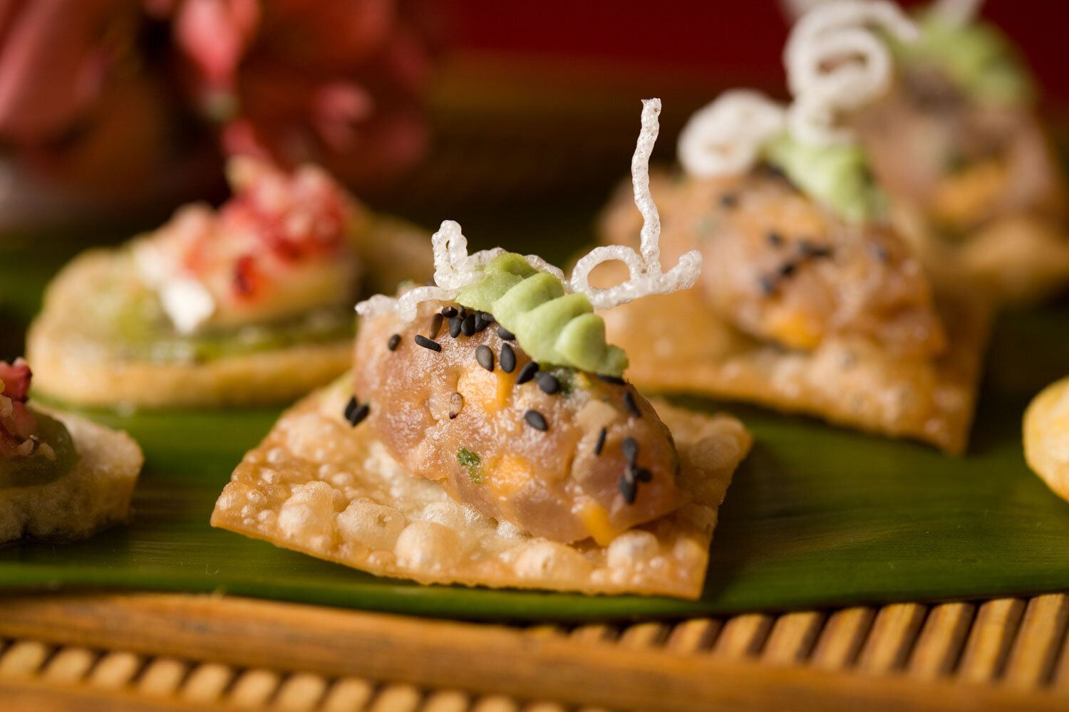 Tuna tartare appetizer on a crispy cracker with wasabi cream