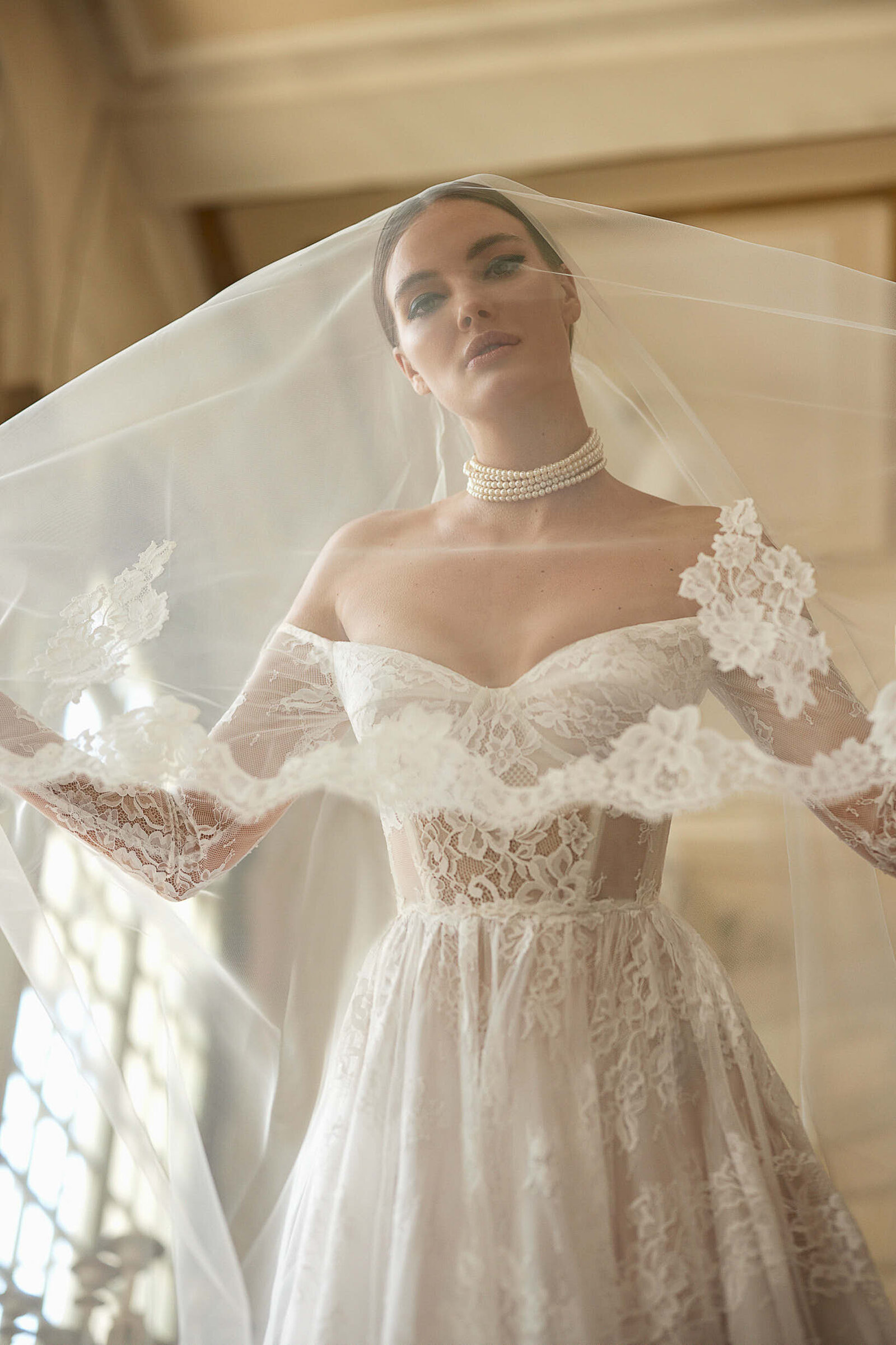 bride wearing white lace wedding dress and long veil
