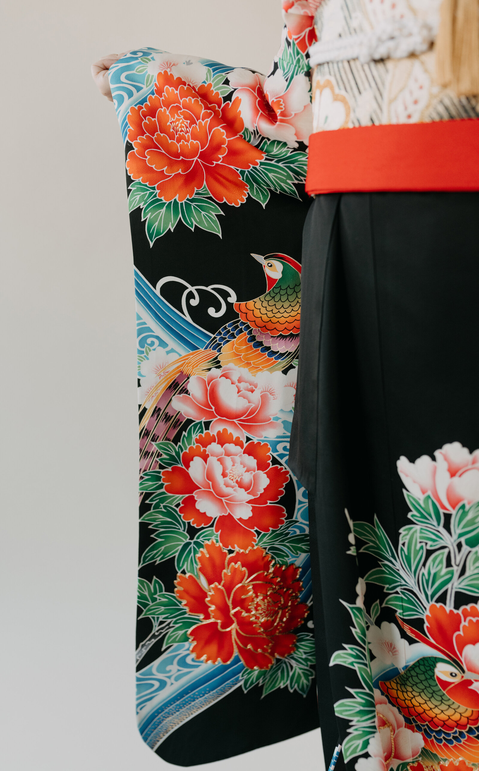 Close-up of black wedding kimono rental sleeve showcasing brilliant peony and pheasant motif, Los Angeles California studio session | 黒引き振袖レンタル 袖アップ 牡丹と雉の華やかな柄 スタジオ撮影