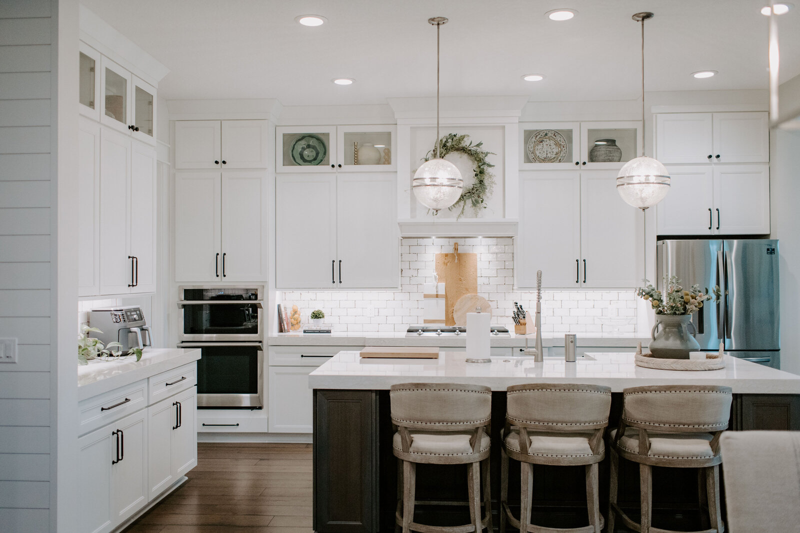 Custom kitchen featuring neutral tones, open shelving, and high-end finishes designed by Holling Home Interiors in St. Augustine, FL.