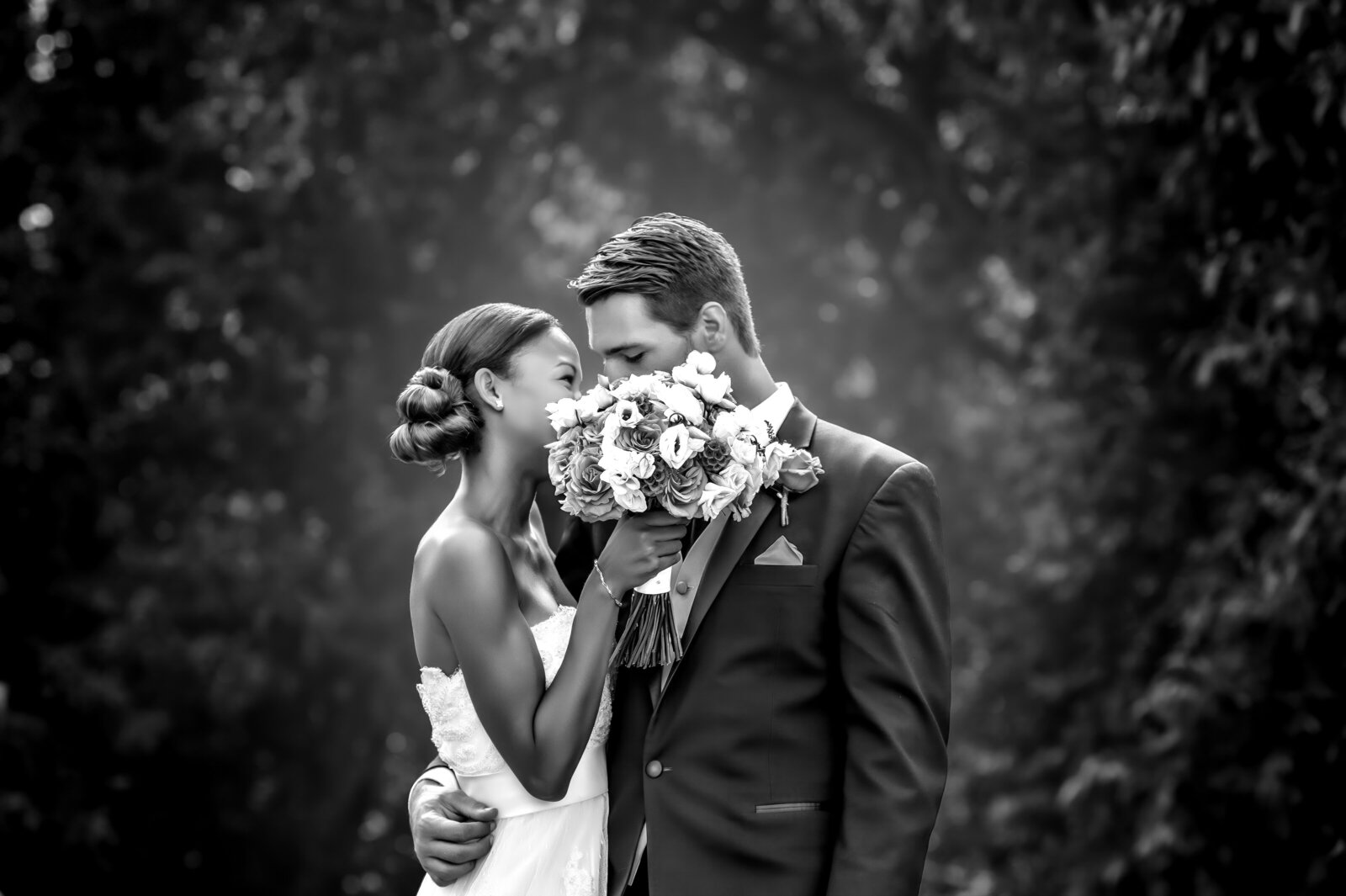 A timeless black and white shot of the bride and groom sharing a romantic kiss after their wedding ceremony, captured by CMH Studios