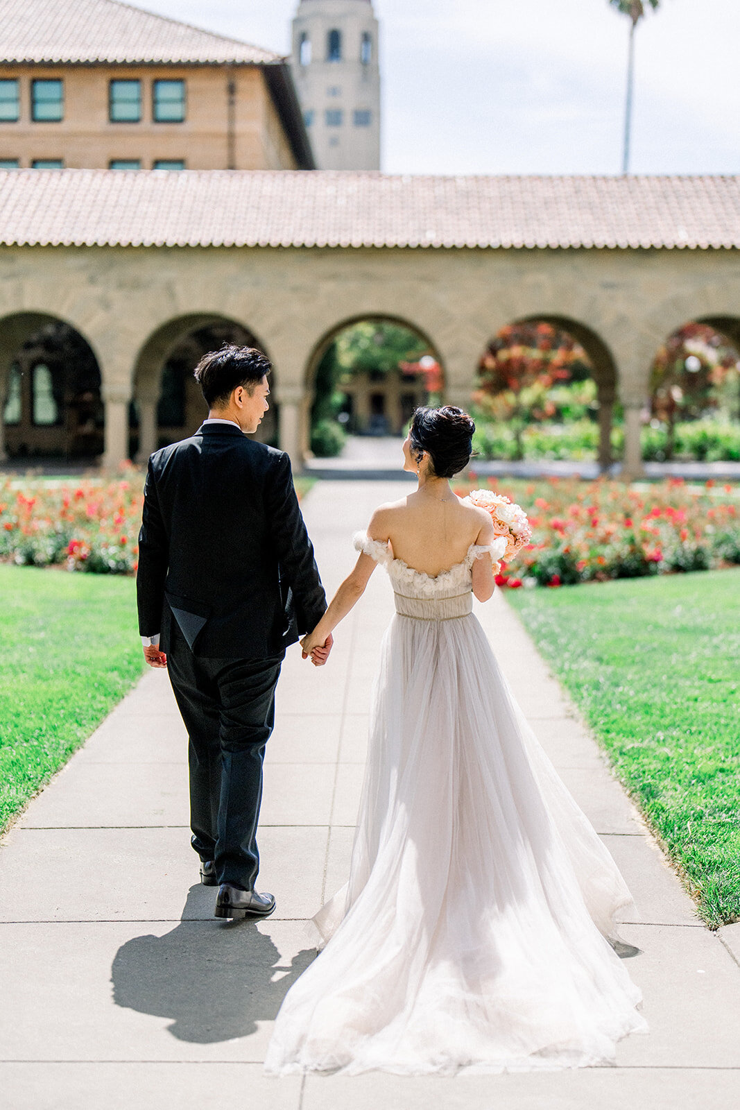 The bride and groom enjoy a romantic walk through Stanford University, capturing a beautiful moment from their California wedding.