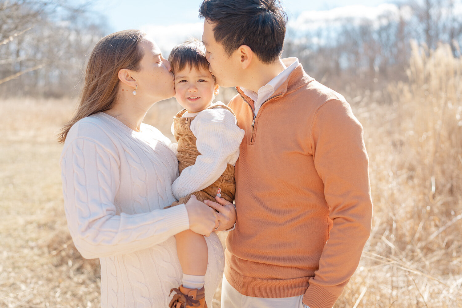 parents kiss son during maternity pictures in Reston, VA