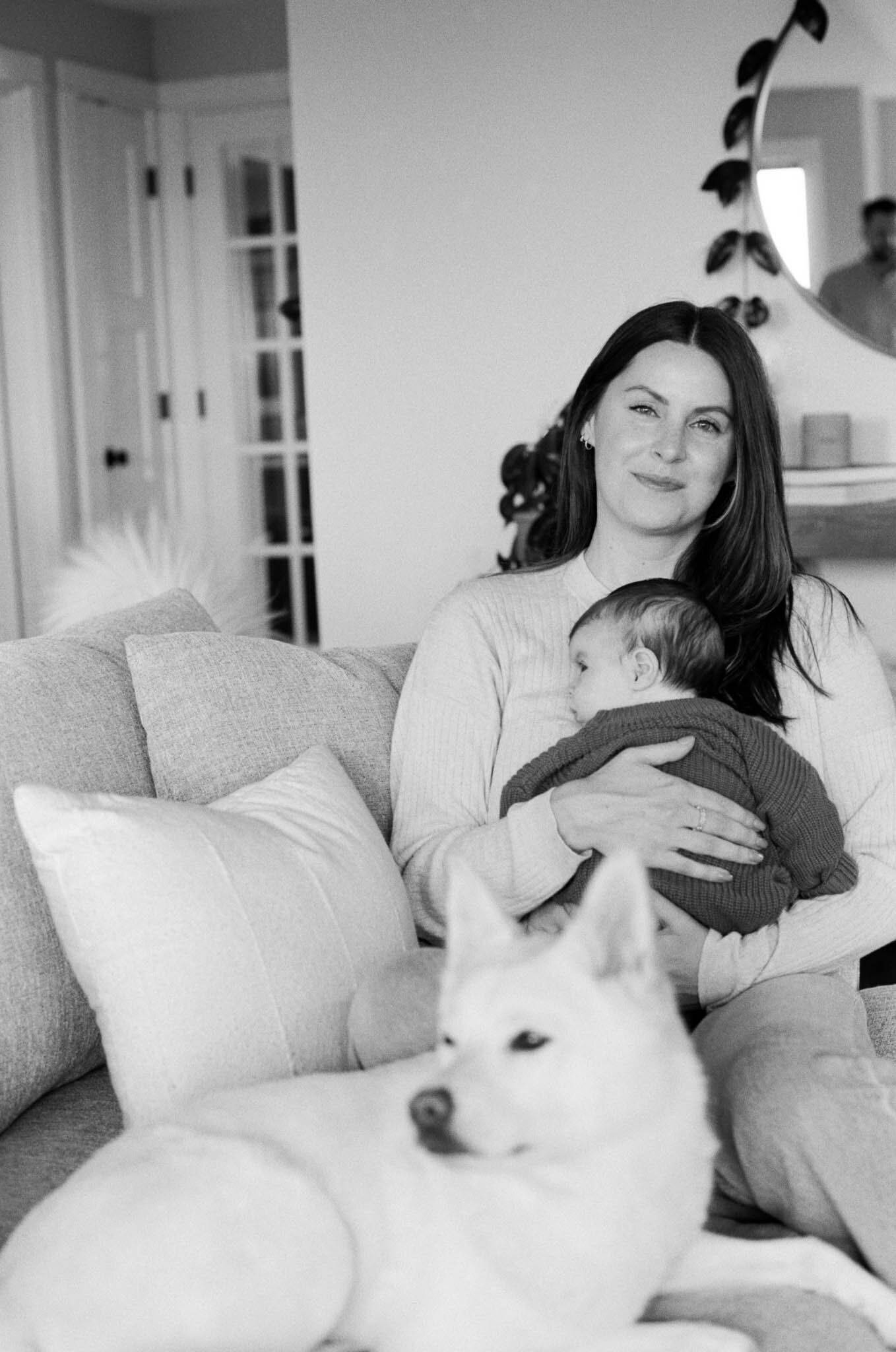 Mother embracing child on the couch with her dog in her Portland, Oregon home.