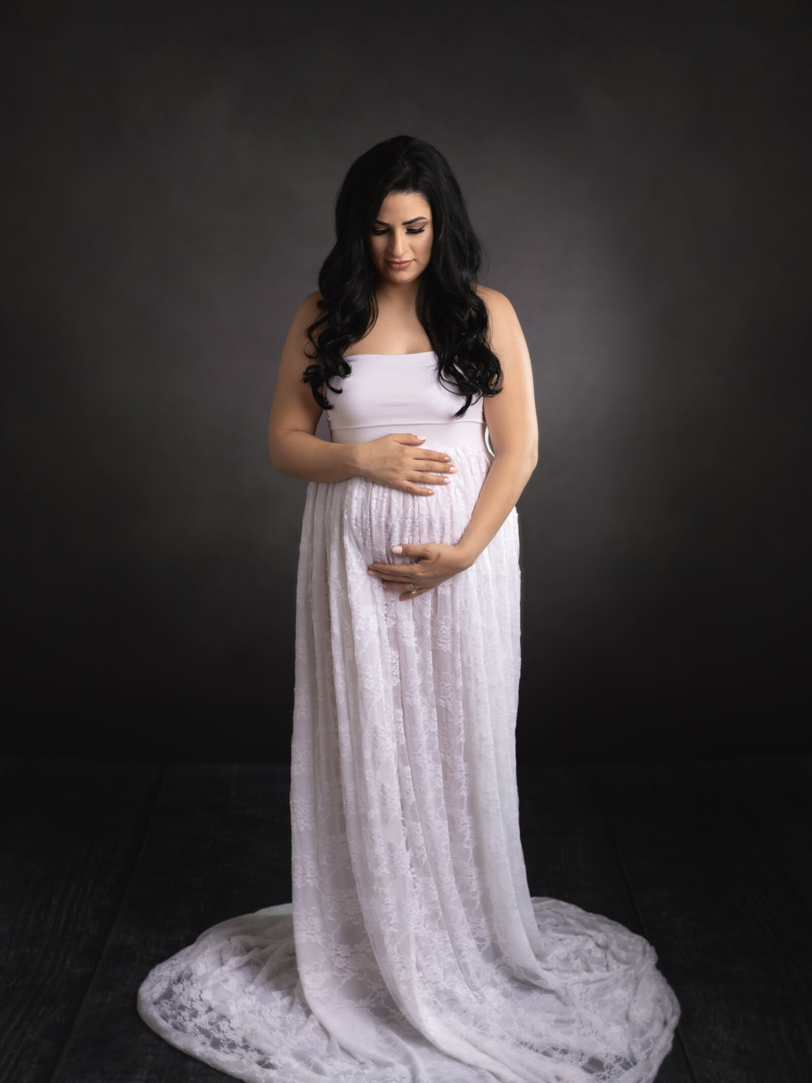 pregnant woman wearing white lace dress for photoshoot