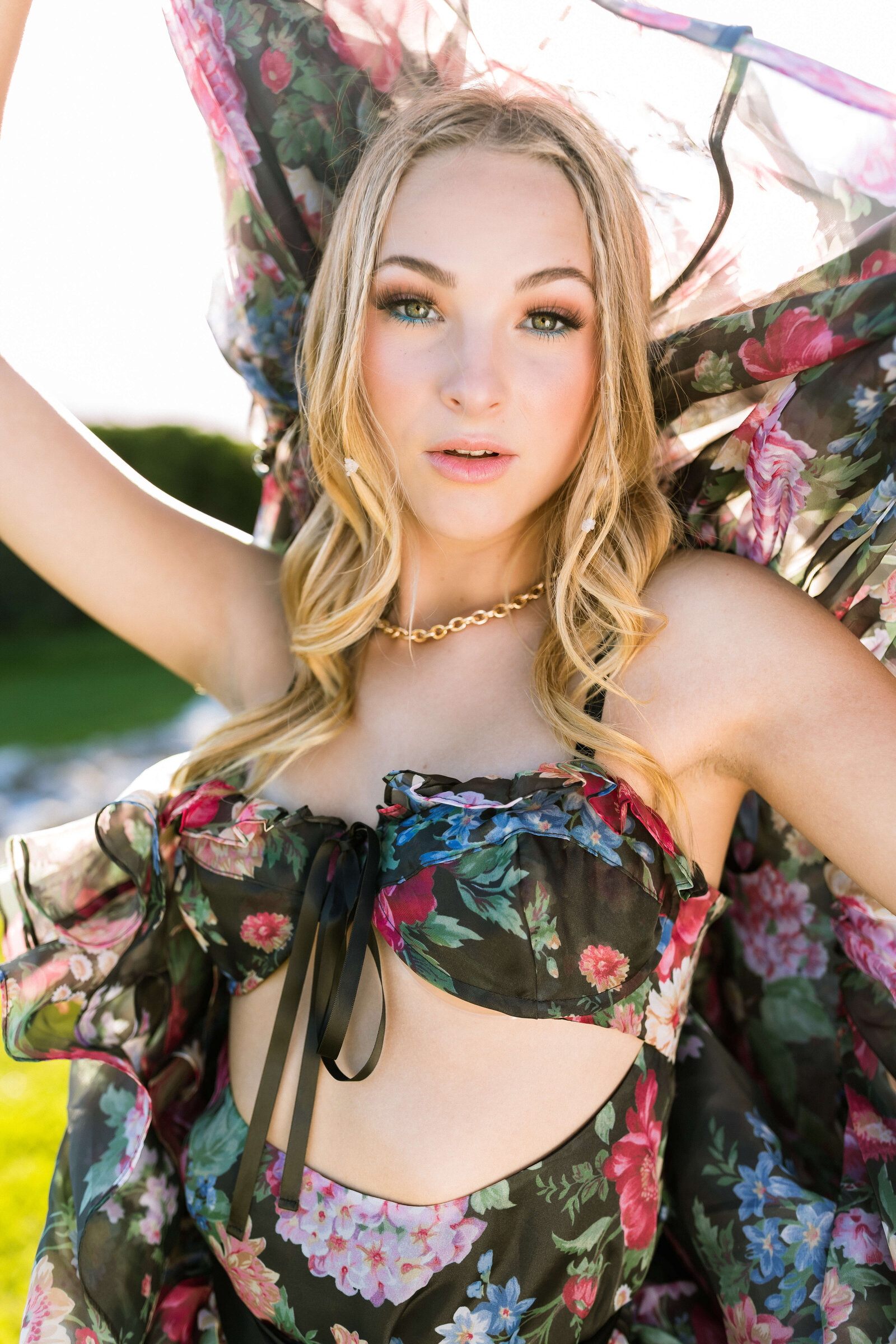 blonde girl wearing dark floral dress with gold jewelry