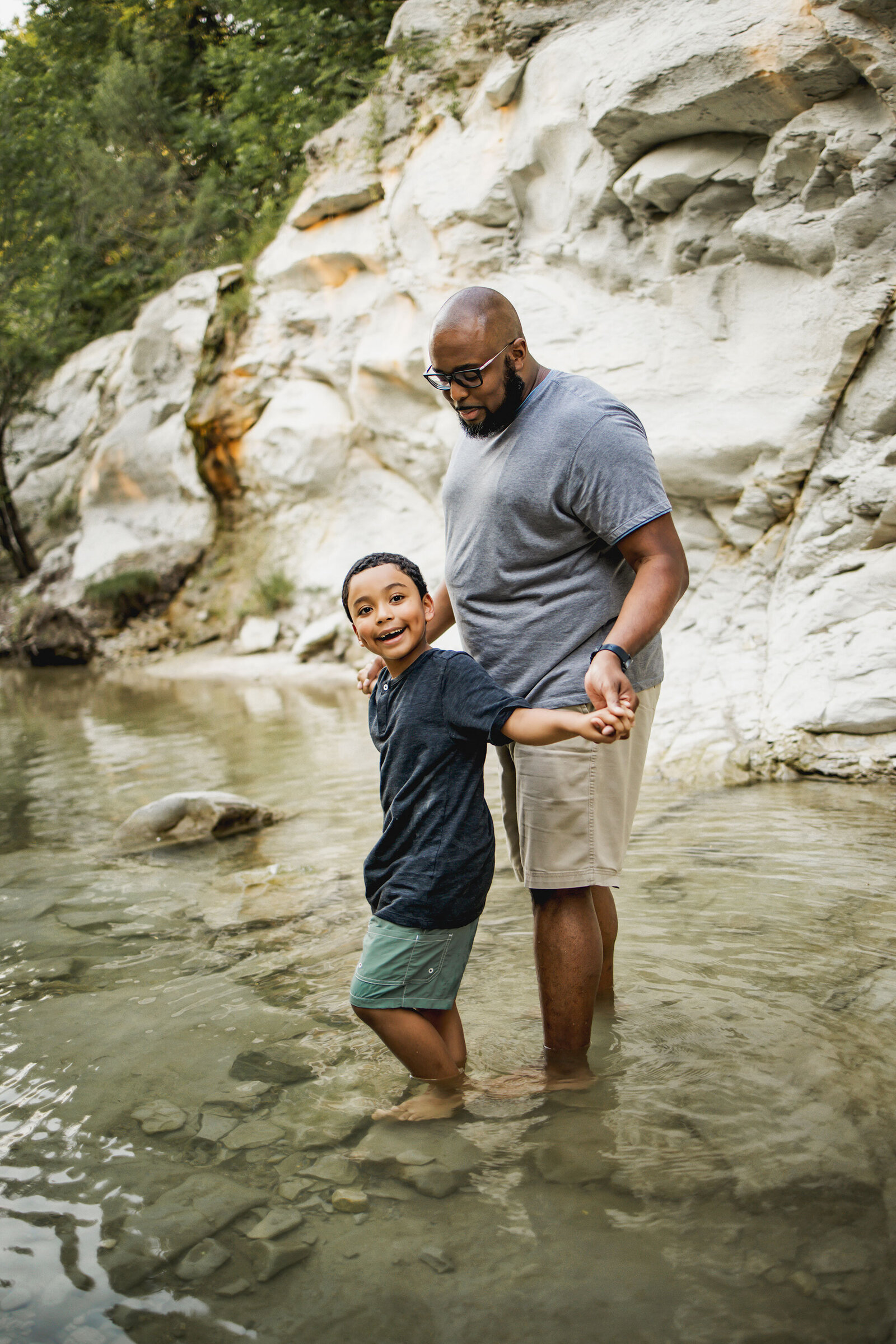 Father and son in a creek in Frisco Texas during a relaxed lifestyle family photo session