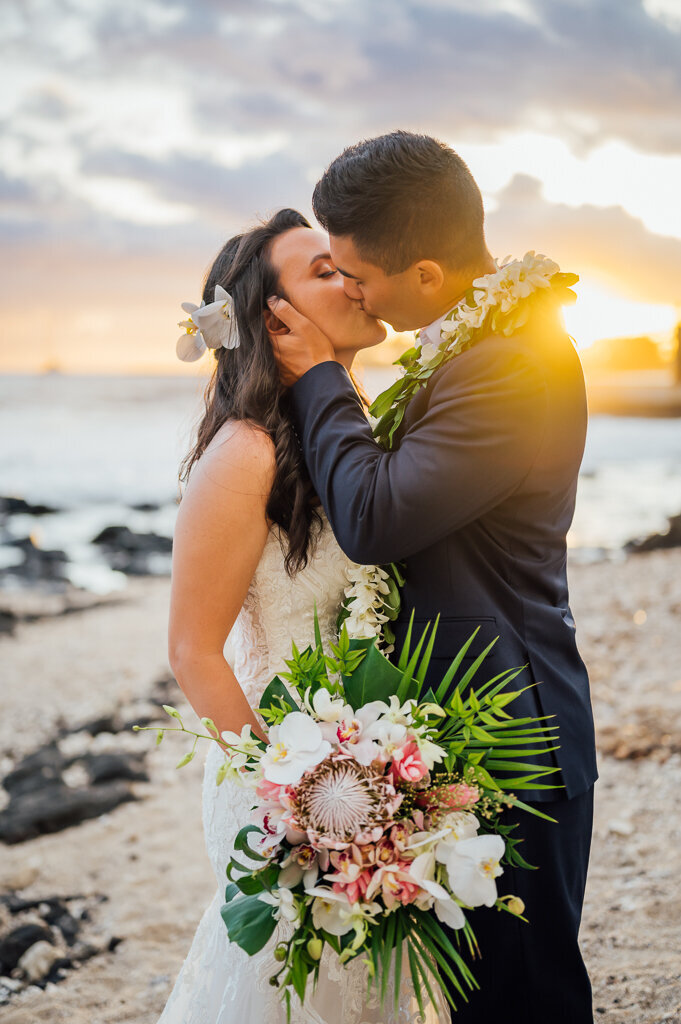 sweet wedding kiss on a big island beach in Kona at sunset