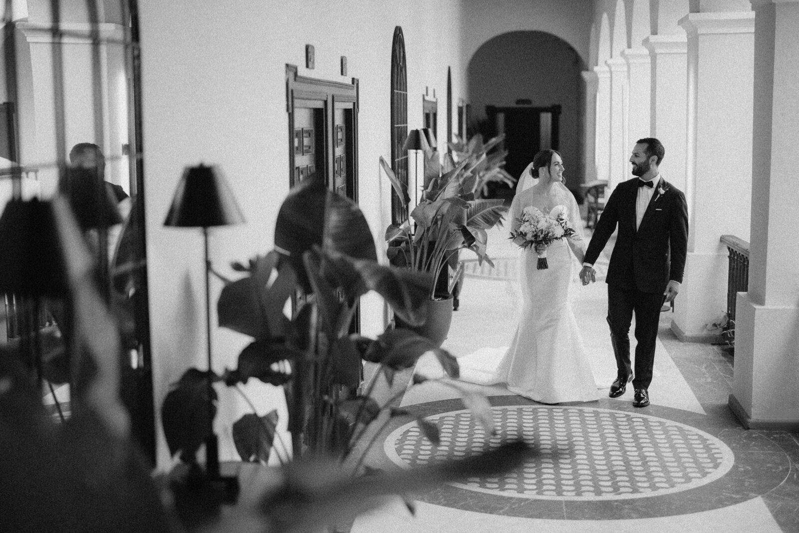 A smiling couple walking through the hallways of El Convento Hotel in Old San Juan, Puerto Rico.