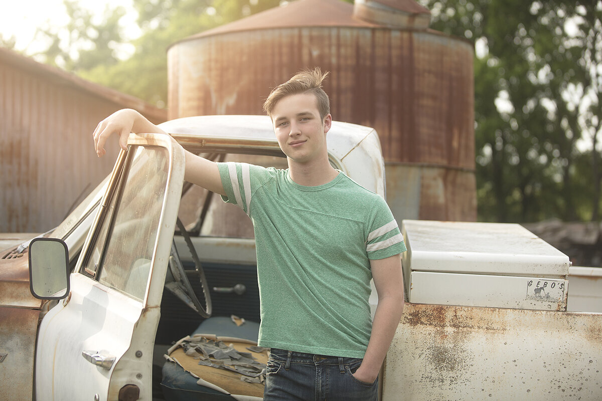 Senior boy poses with vintage truck at dallas senior photo session