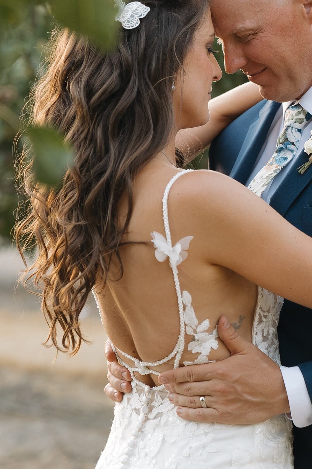Bride and groom embracing in the orchard at golden hour