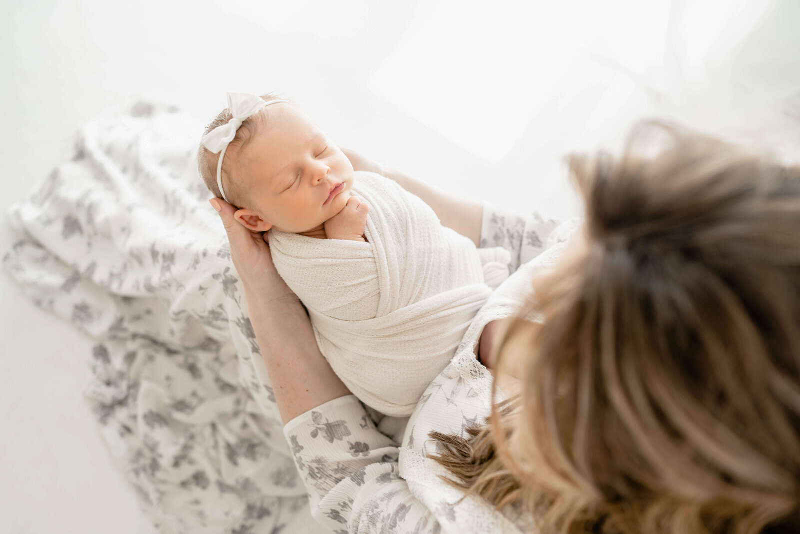 oklahoma city mother looking down at her perfect new daughter