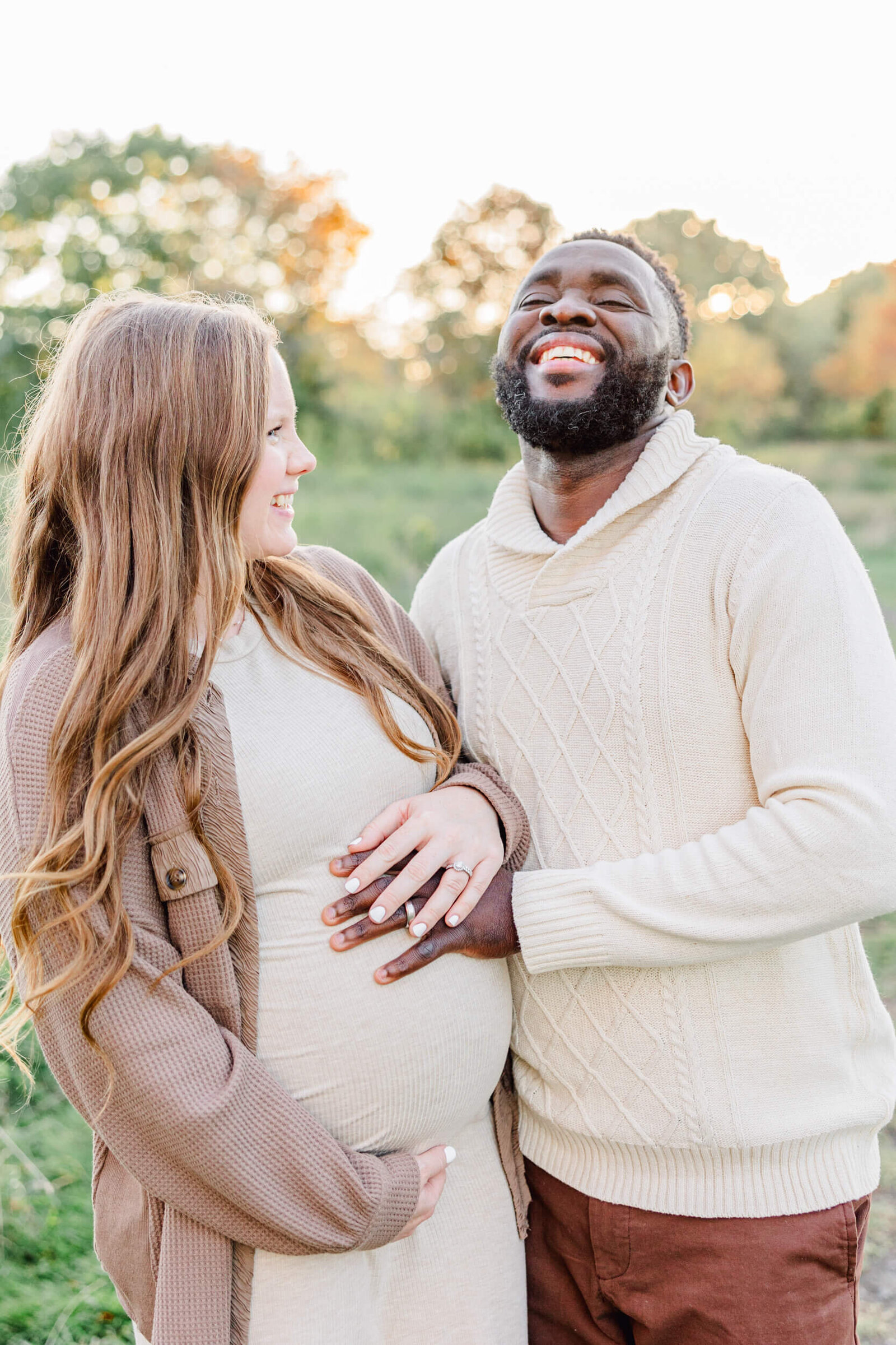 Pregnant woman smiles at her laughing husband