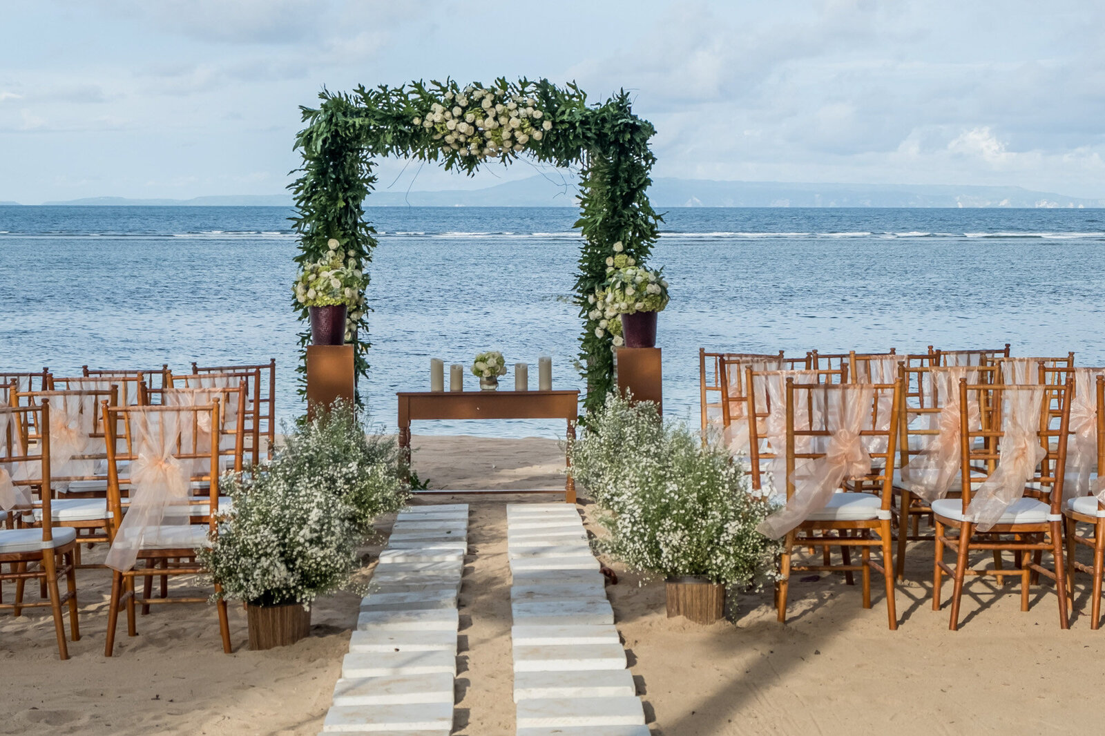 Beach wedding ceremony site with elegant florals