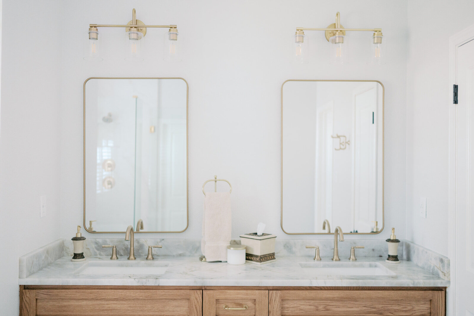 dual sink vanity with marble countertop and gold fixtures