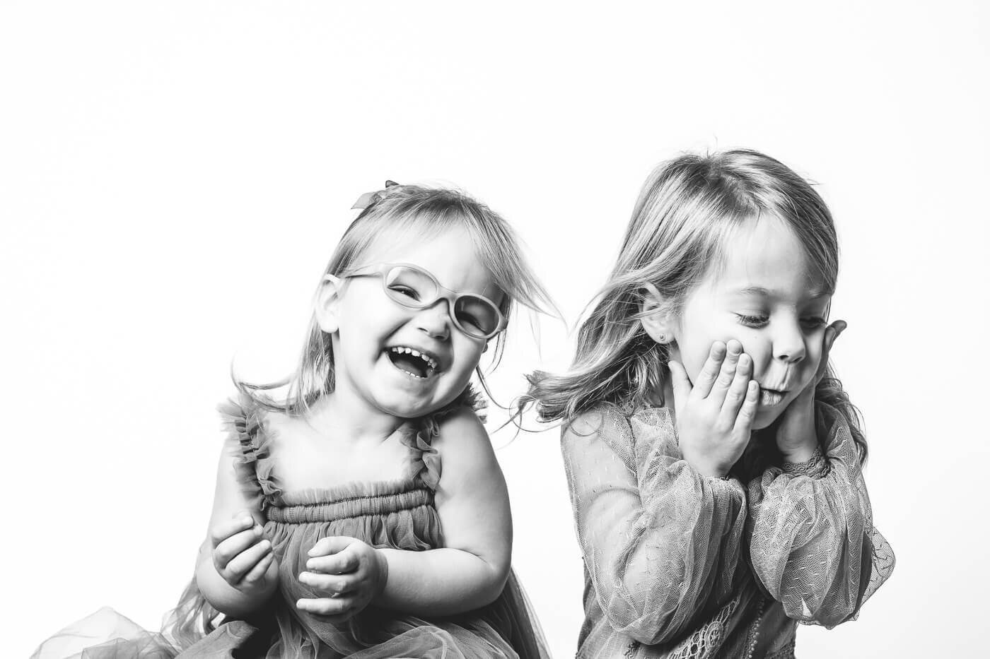 Younger sister irrupting in laughter because of playful older sister
