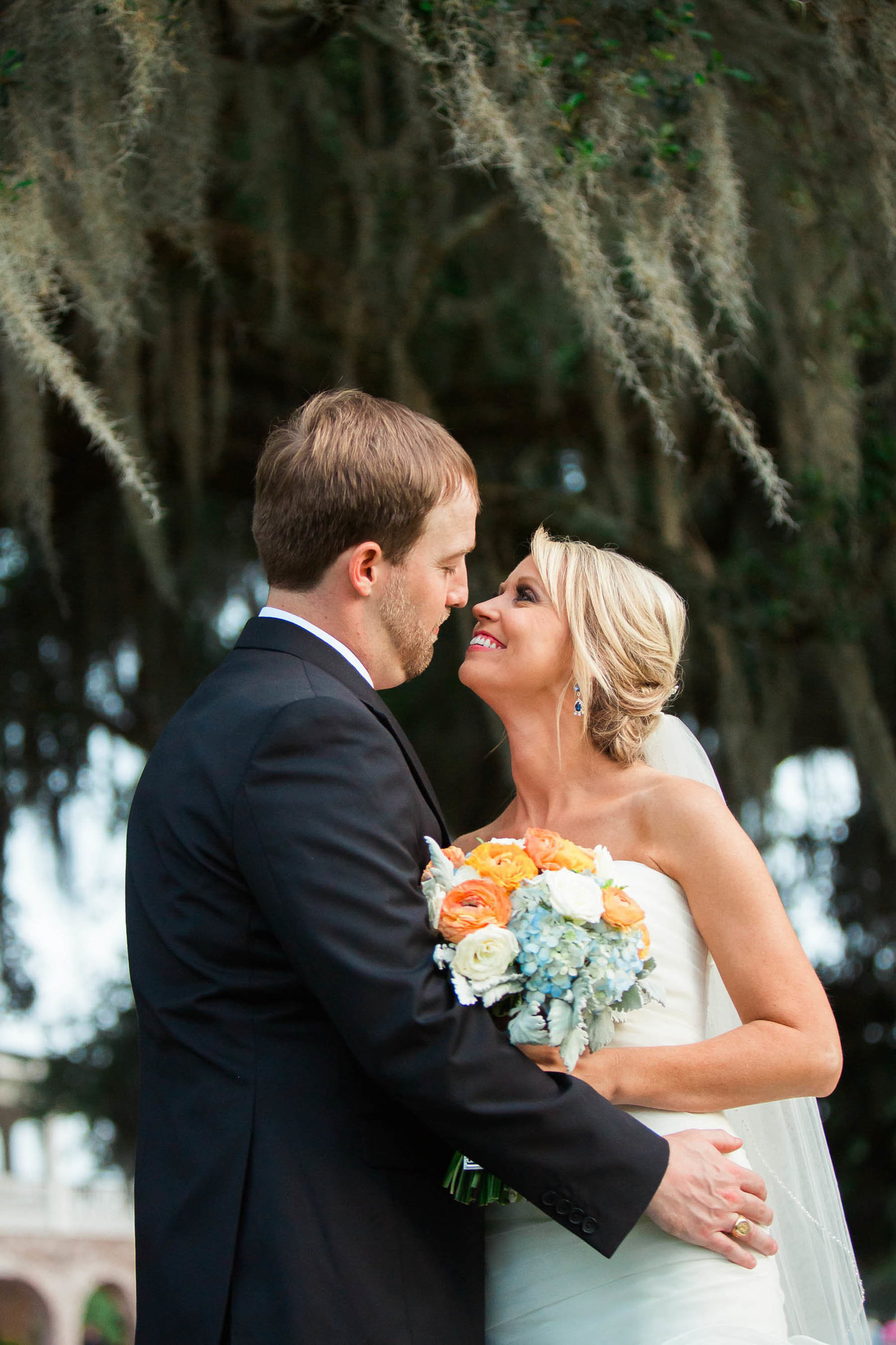 Bride and groom smile under oak trees, Dunes West Golf and River Club, Mt Pleasant, South Carolina