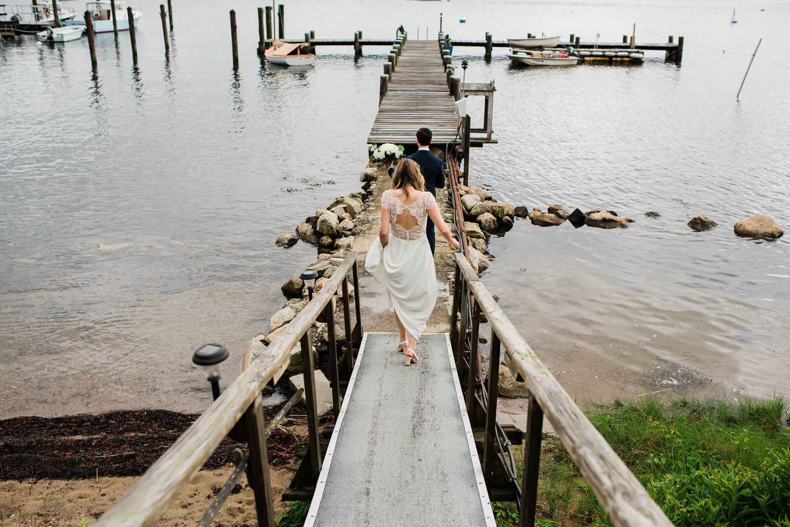 bride and groom walking to dock from behind