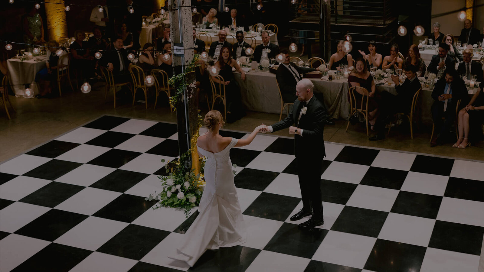 A bride and groom joyfully dance on a checkered floor, celebrating their union at Winslow Baltimore, photographed by Get Ready Photo.