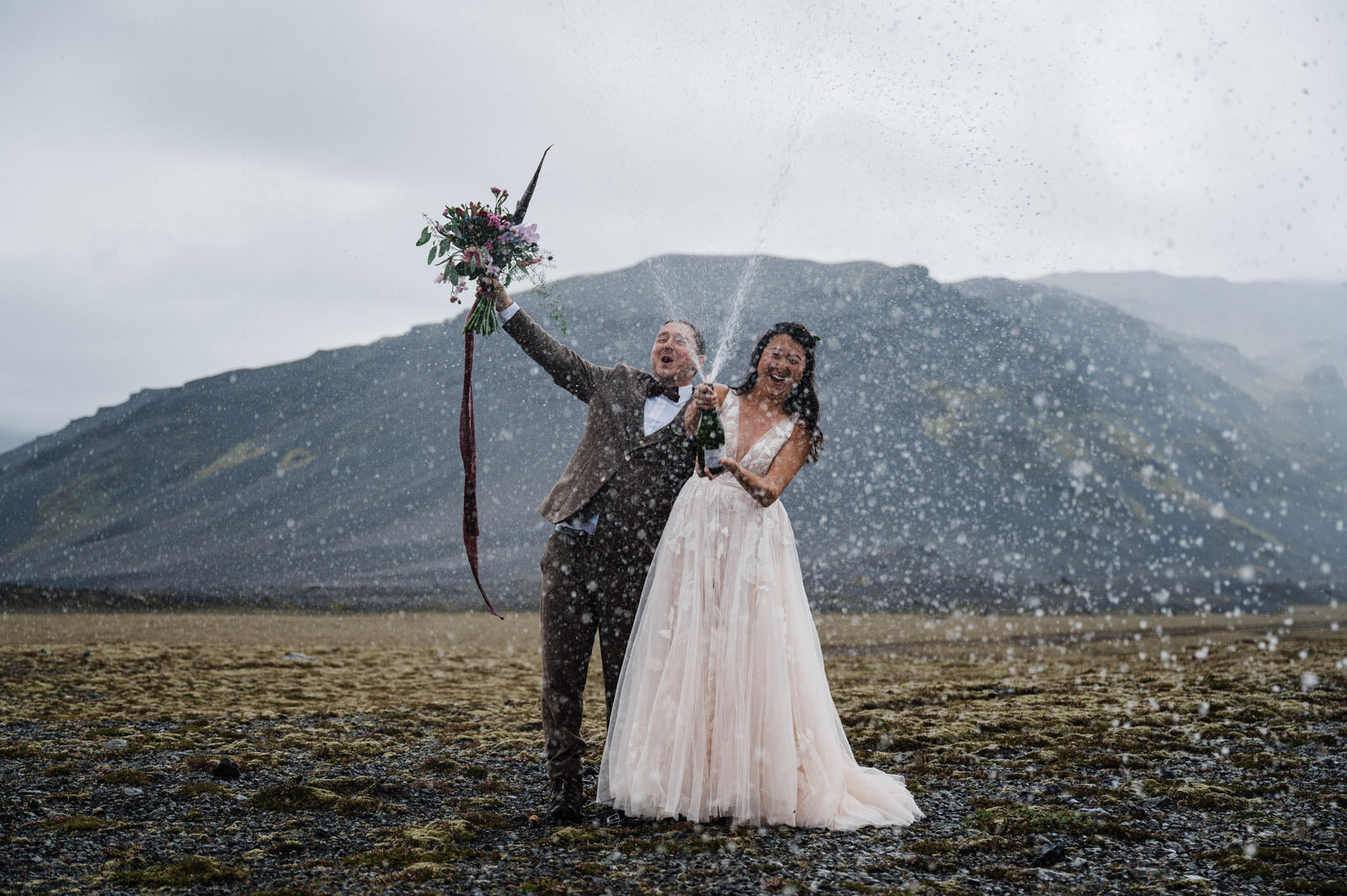 couple eloping in iceland and popping champagne near a glacier