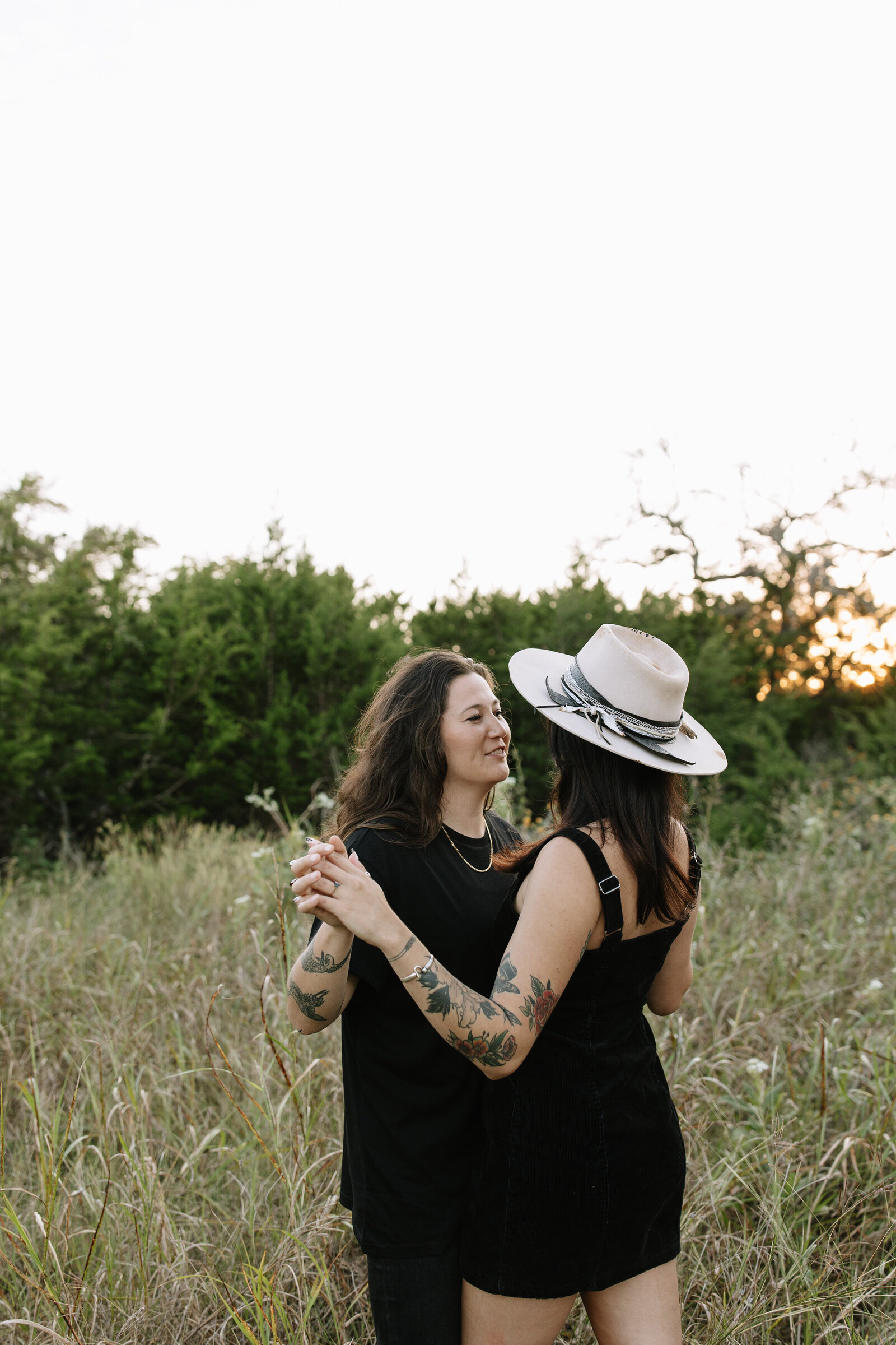 Two women laughing and hugging during sun-drenched Austin session
