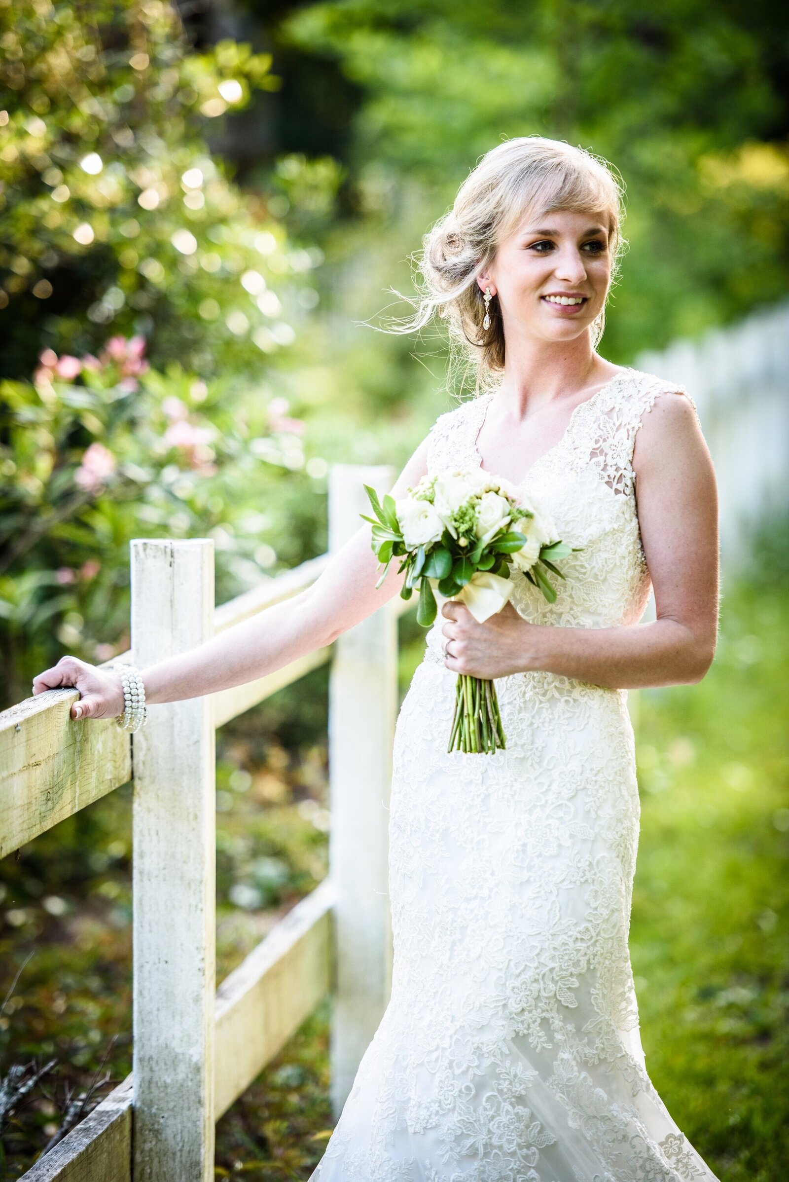 Bride by white fence at Maison Gauthier The Old Place