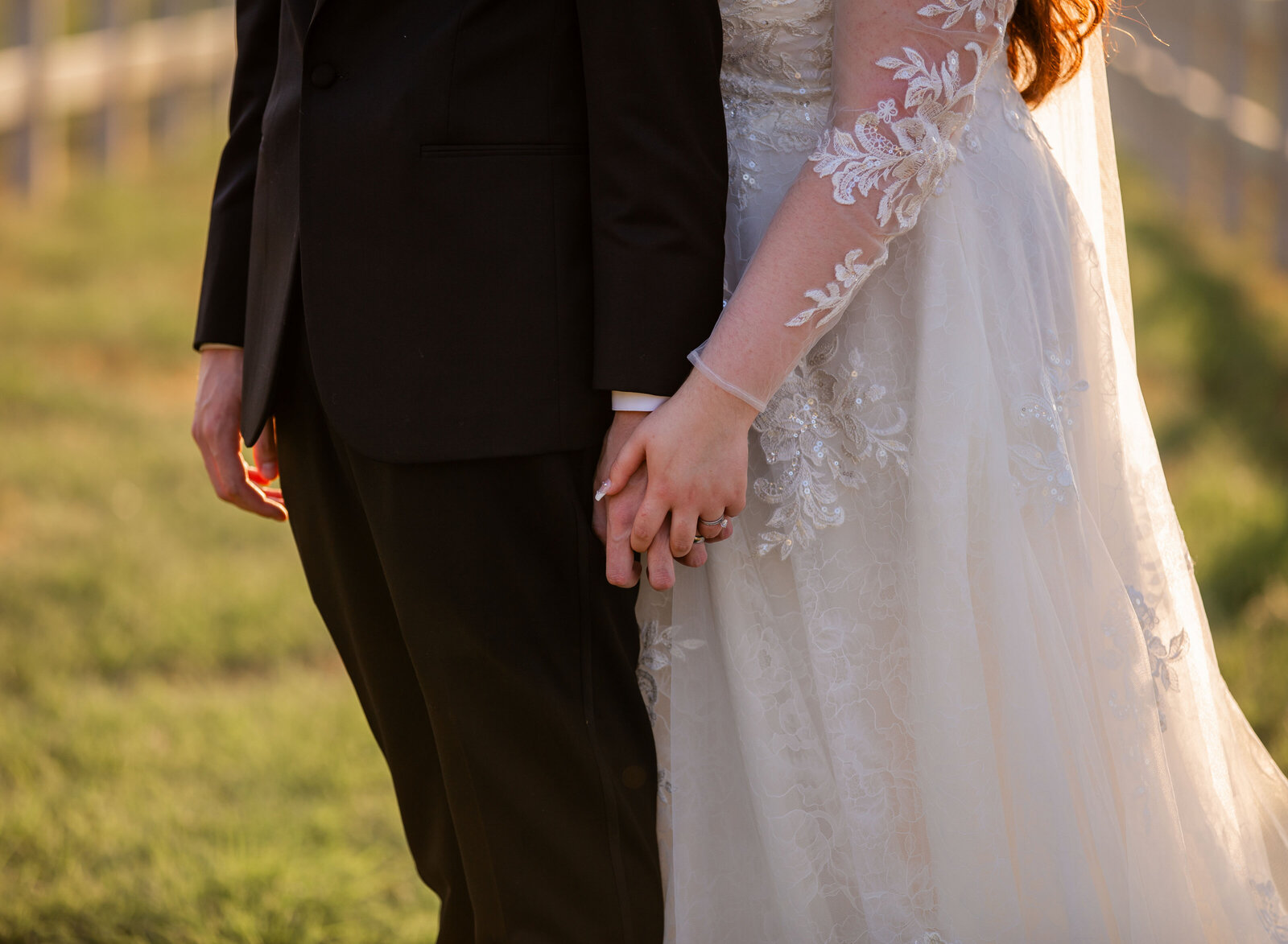 closeup of bride and groom holding hands
