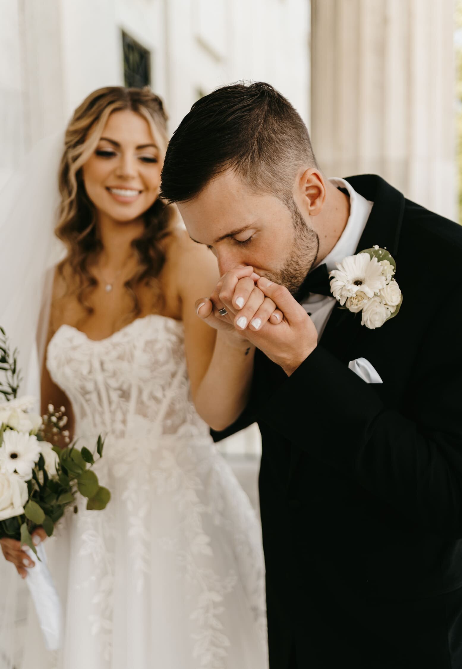groom-kisses-brides-hand-home