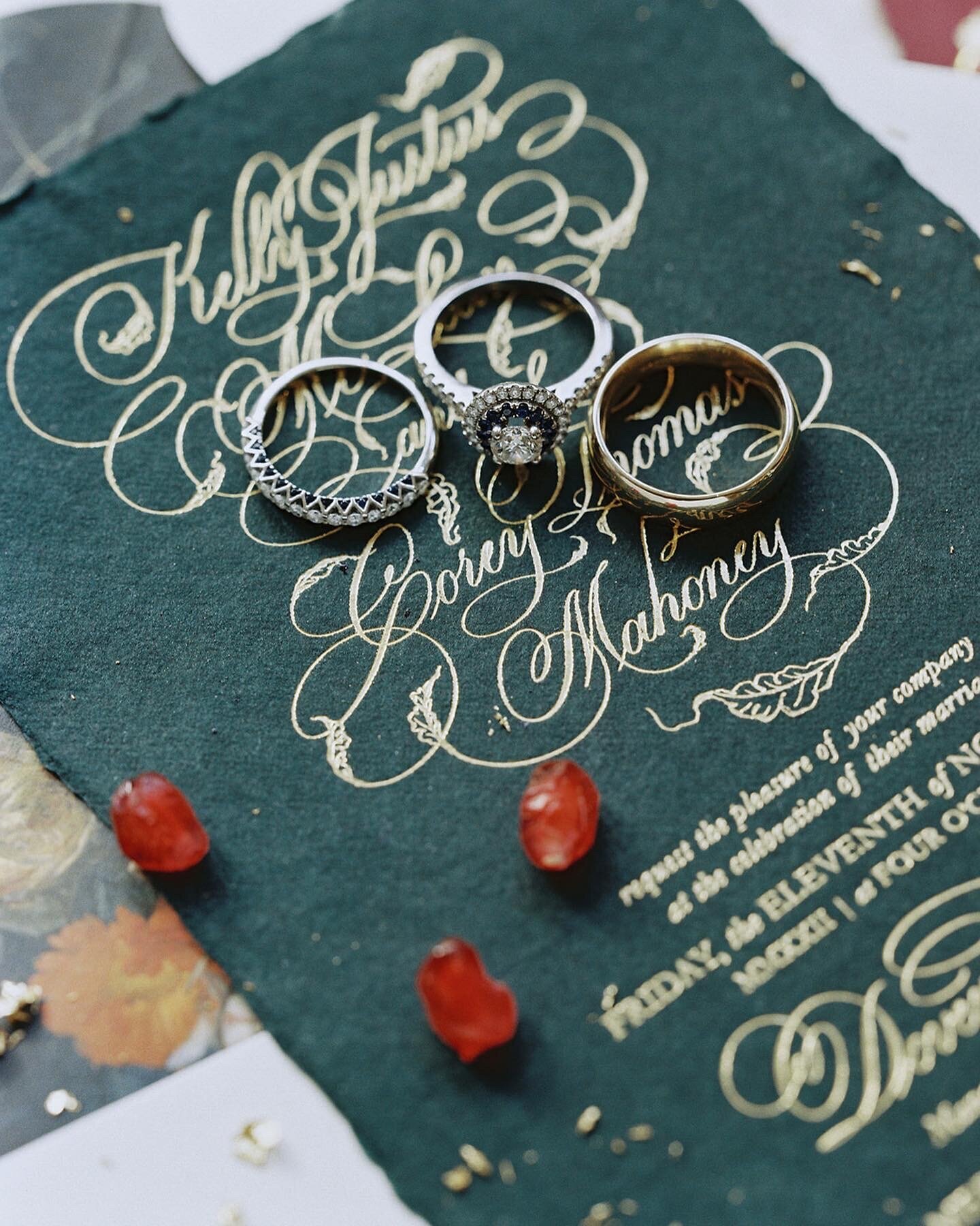 Green themed wedding invitation with calligraphy and the wedding bands on top