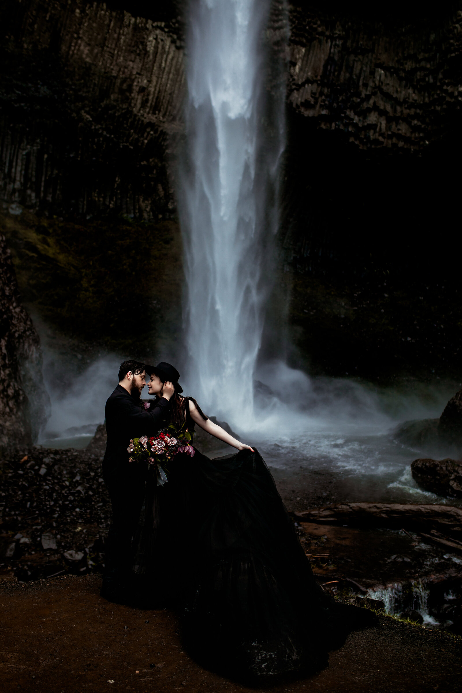 Bride posed gracefully in front of a misty waterfall, perfect for styled shoots for adventurous photographers in the Pacific Northwest.